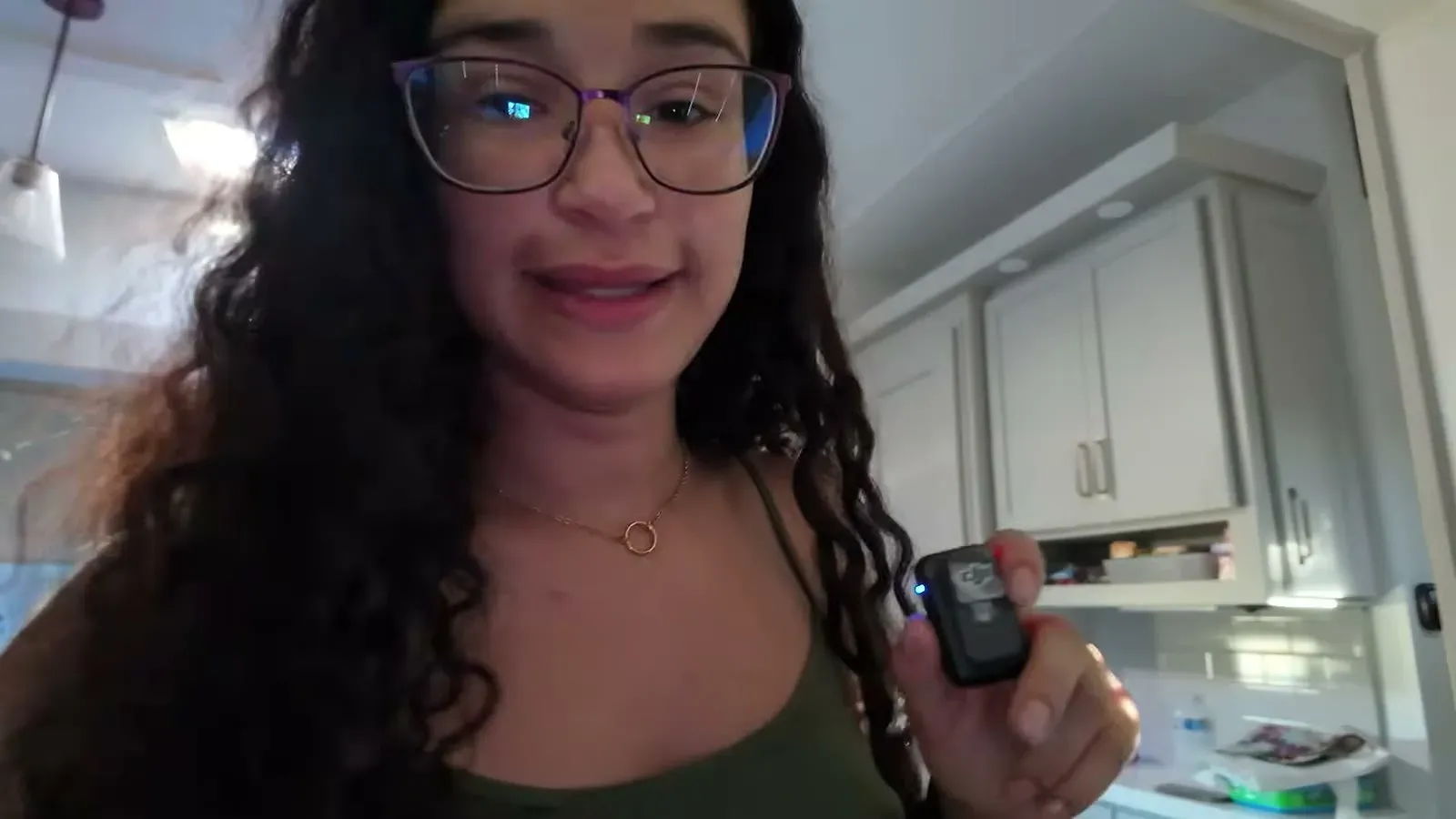 Fabiola in the RV kitchen holding the thermometer remote on a 105 degree Badlands morning