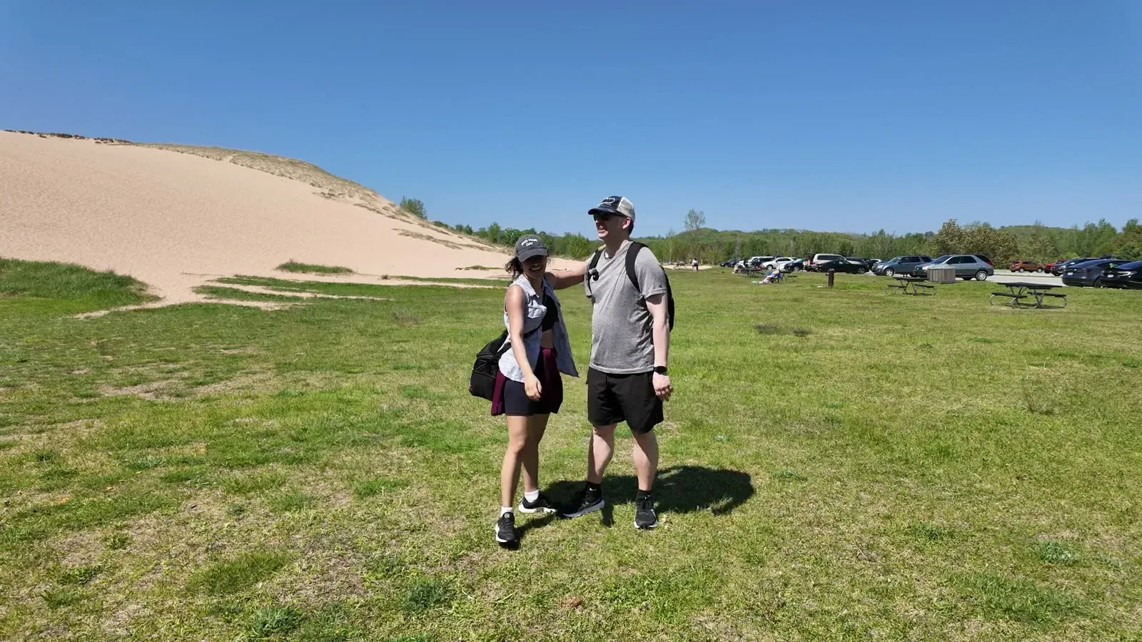 Sandy and tired but smiling on the grass at the base of the Dune Climb after finishing the round trip.