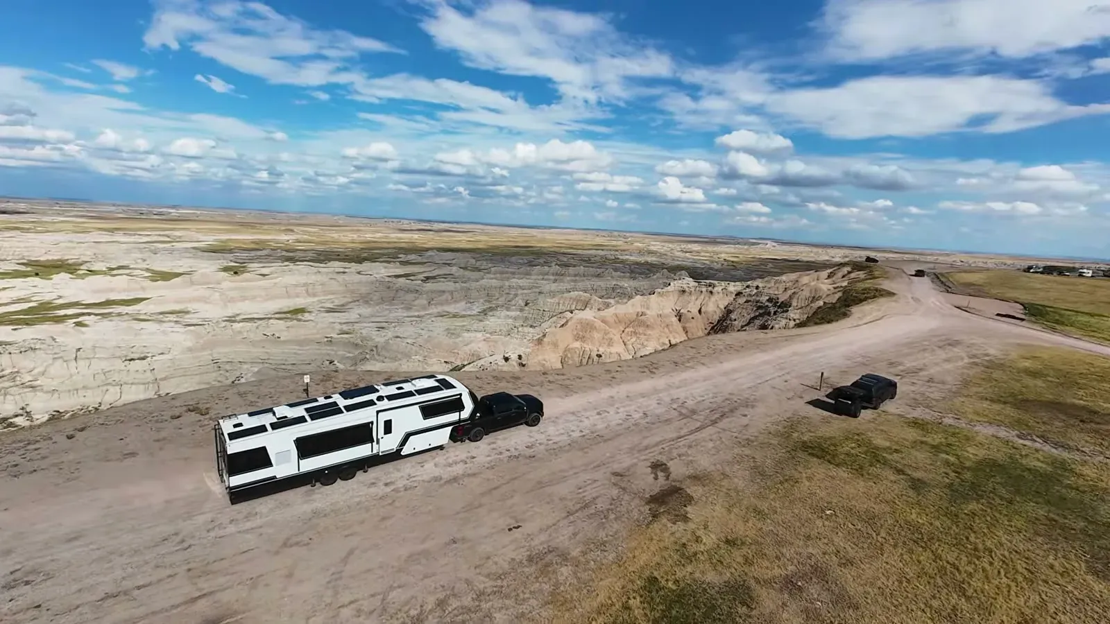 Aerial view of our Brinkley fifth wheel parked on the Badlands rim, showing the full run of solar panels covering the roof