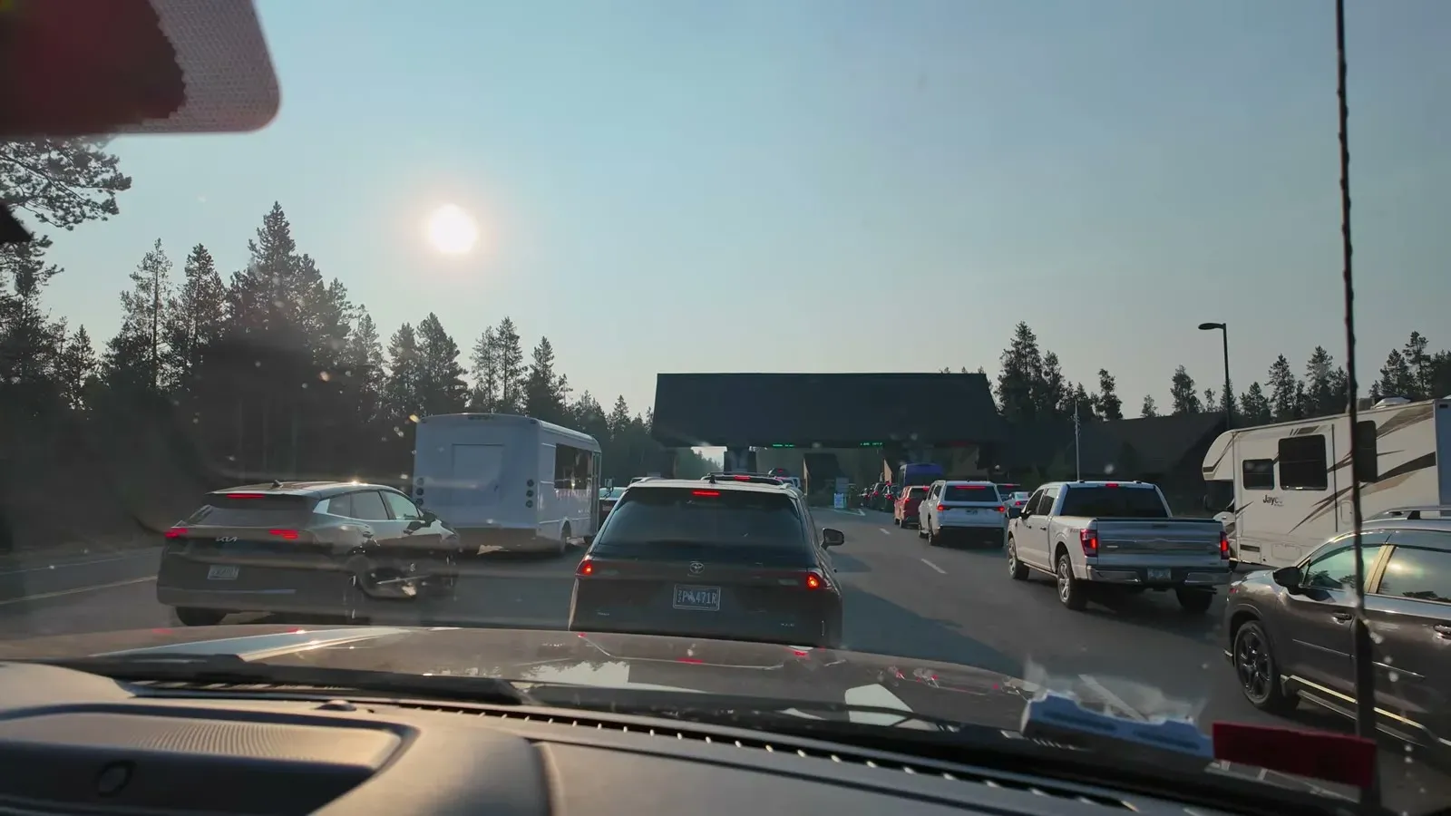 A line of cars and RVs queued at the Yellowstone west entrance station in early morning light