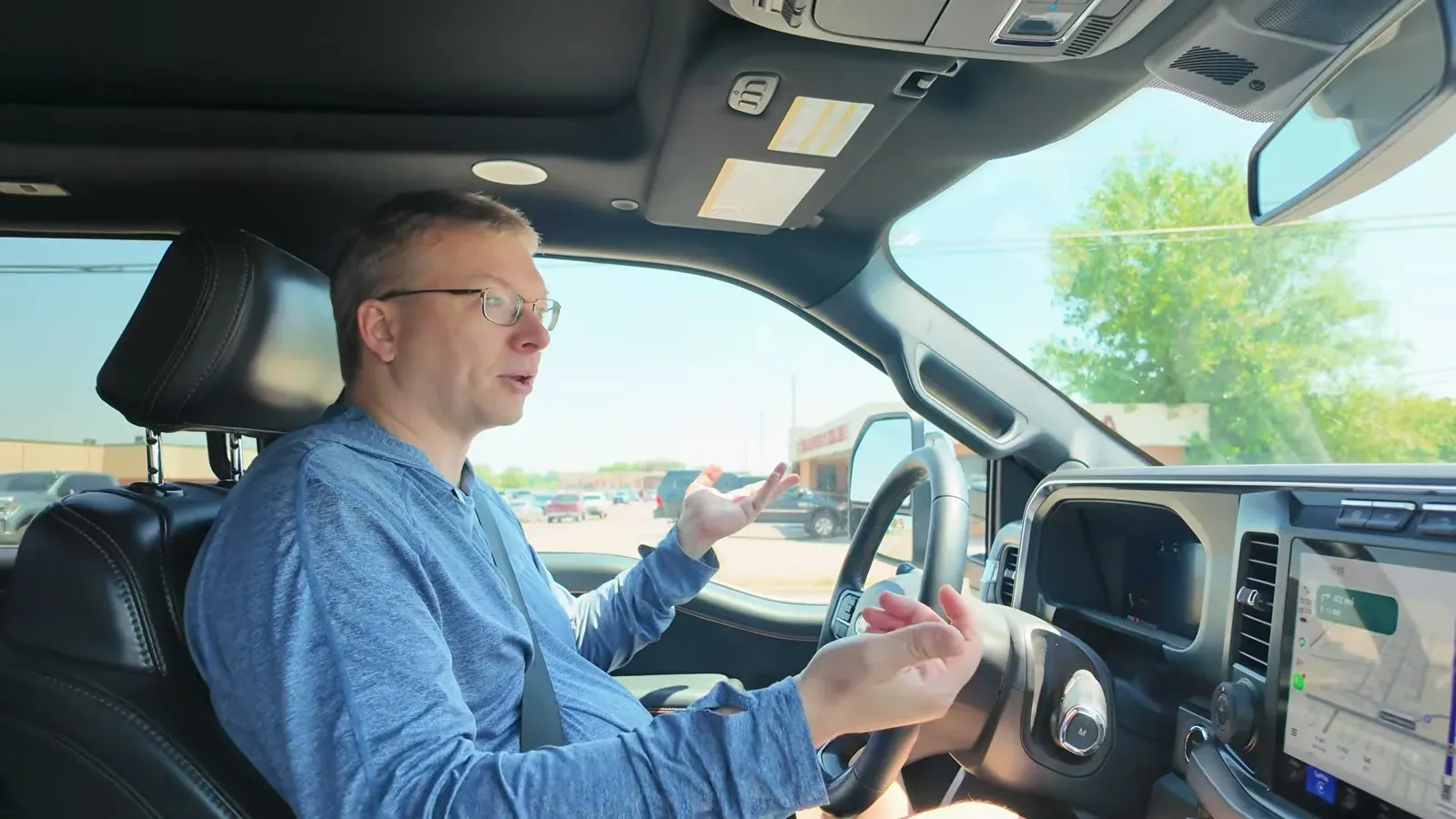 Nathan at the wheel of the truck talking to the camera on the drive out of Rapid City