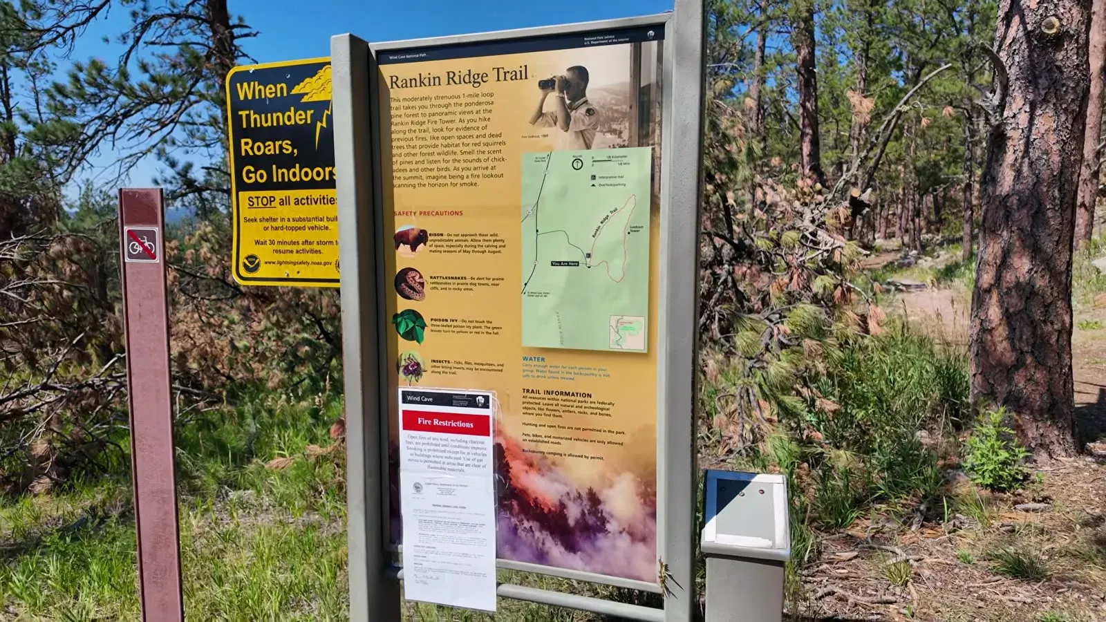 The Rankin Ridge Trail information sign and map at the trailhead, beside a yellow lightning safety sign