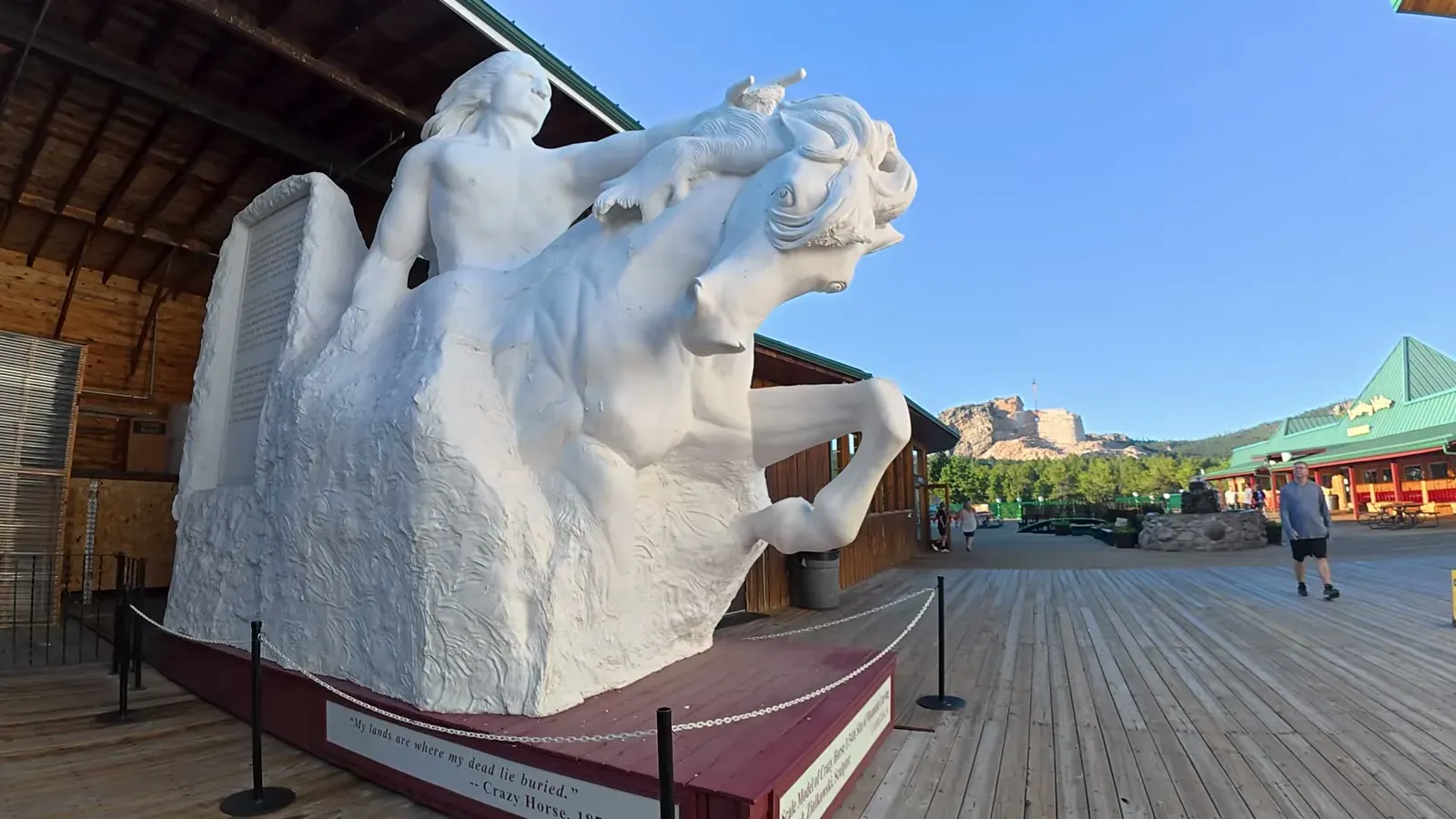 The white scale model of the Crazy Horse sculpture on the viewing deck, with the carved mountain visible behind it
