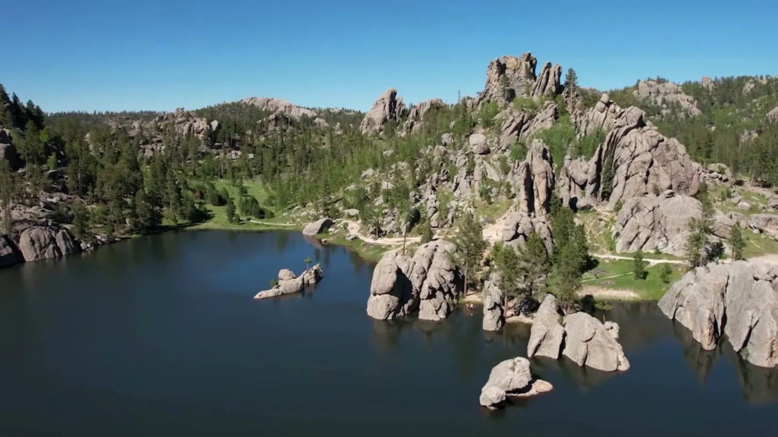 Sylvan Lake seen from above, ringed by granite boulders and pine forest in Custer State Park