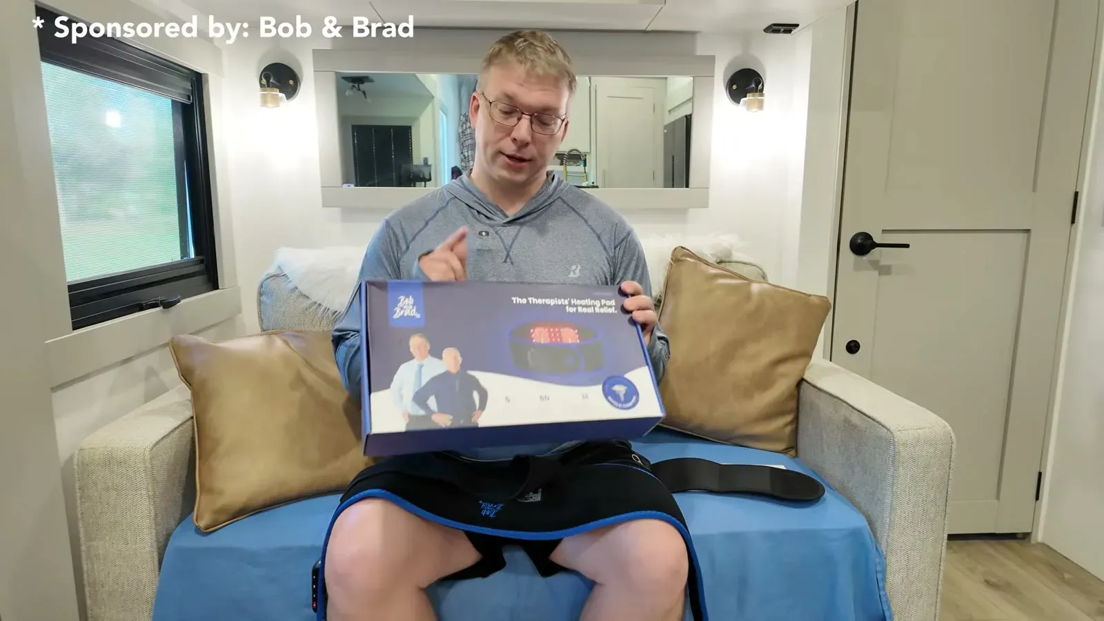 Nathan sitting in the RV holding the Bob and Brad ThermoRed box with the back belt across his lap