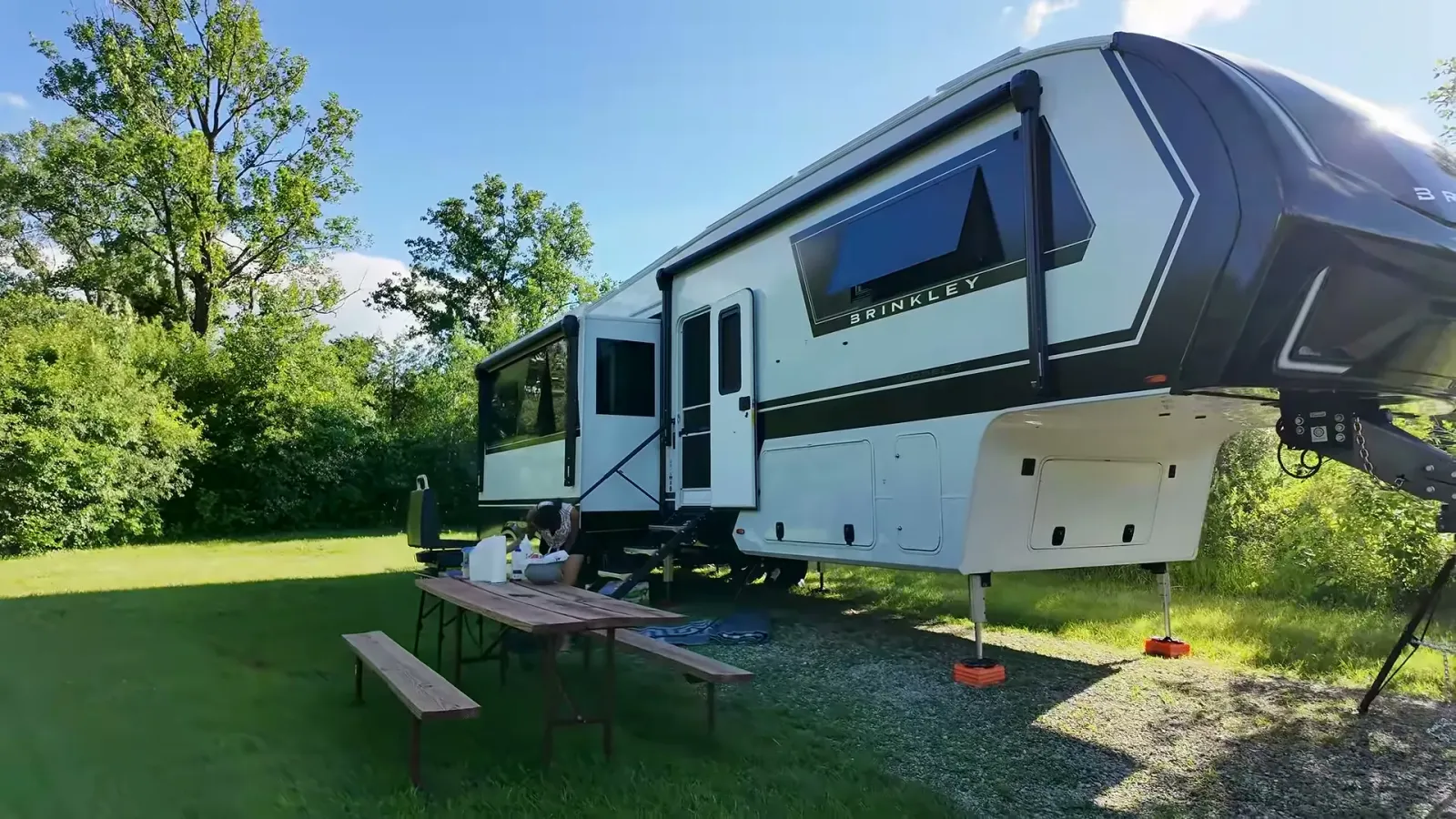 Our Brinkley fifth wheel with the slides out and a picnic table on a grassy site at Richard Bong State Recreation Area
