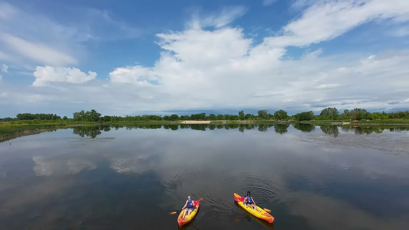 Drone shot of two kayaks on the calm lake at Richard Bong State Recreation Area under a blue sky with clouds