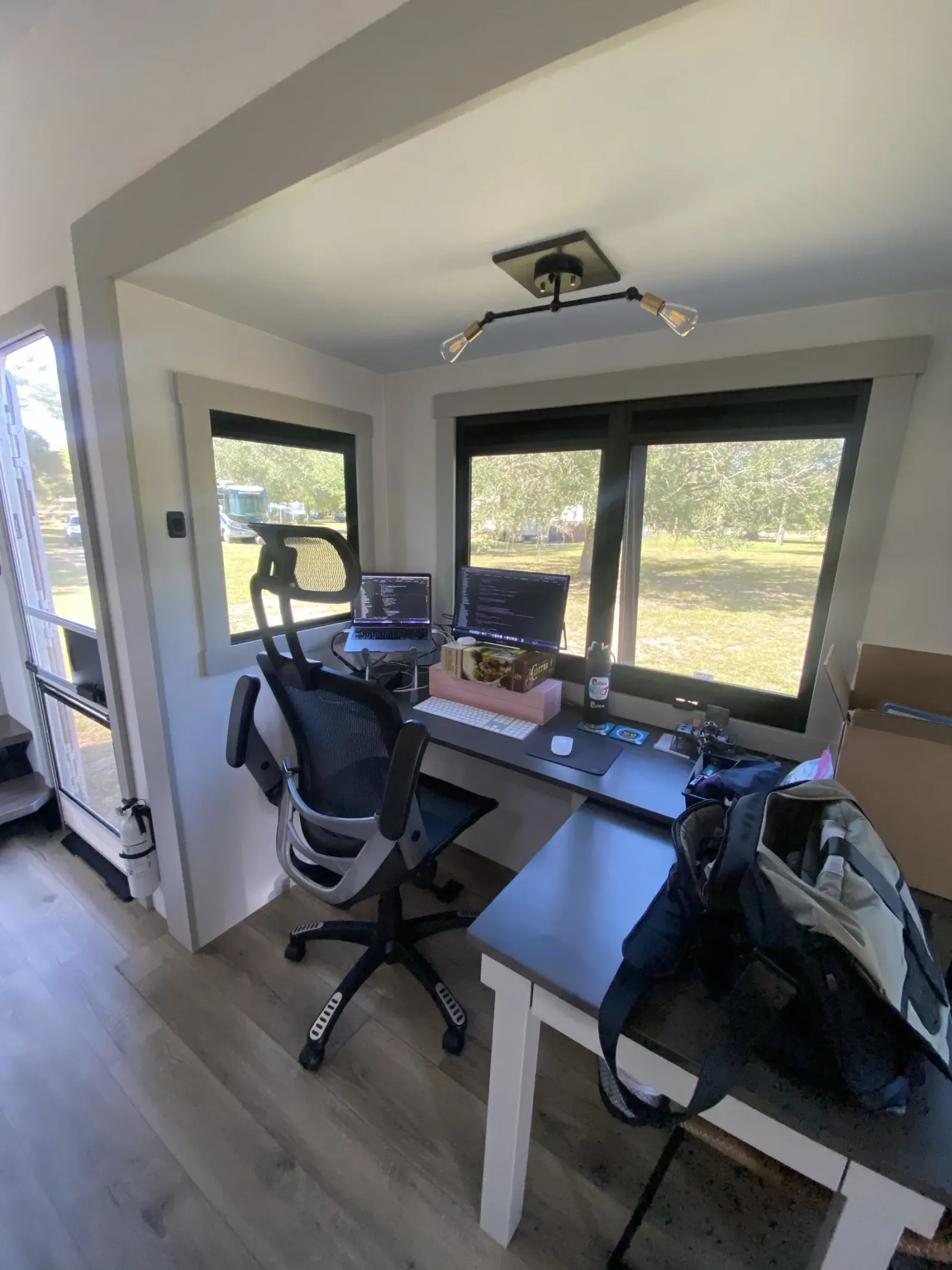 The rear office of our Brinkley Model Z 3515 with two desks, laptops, a rolling office chair and large windows