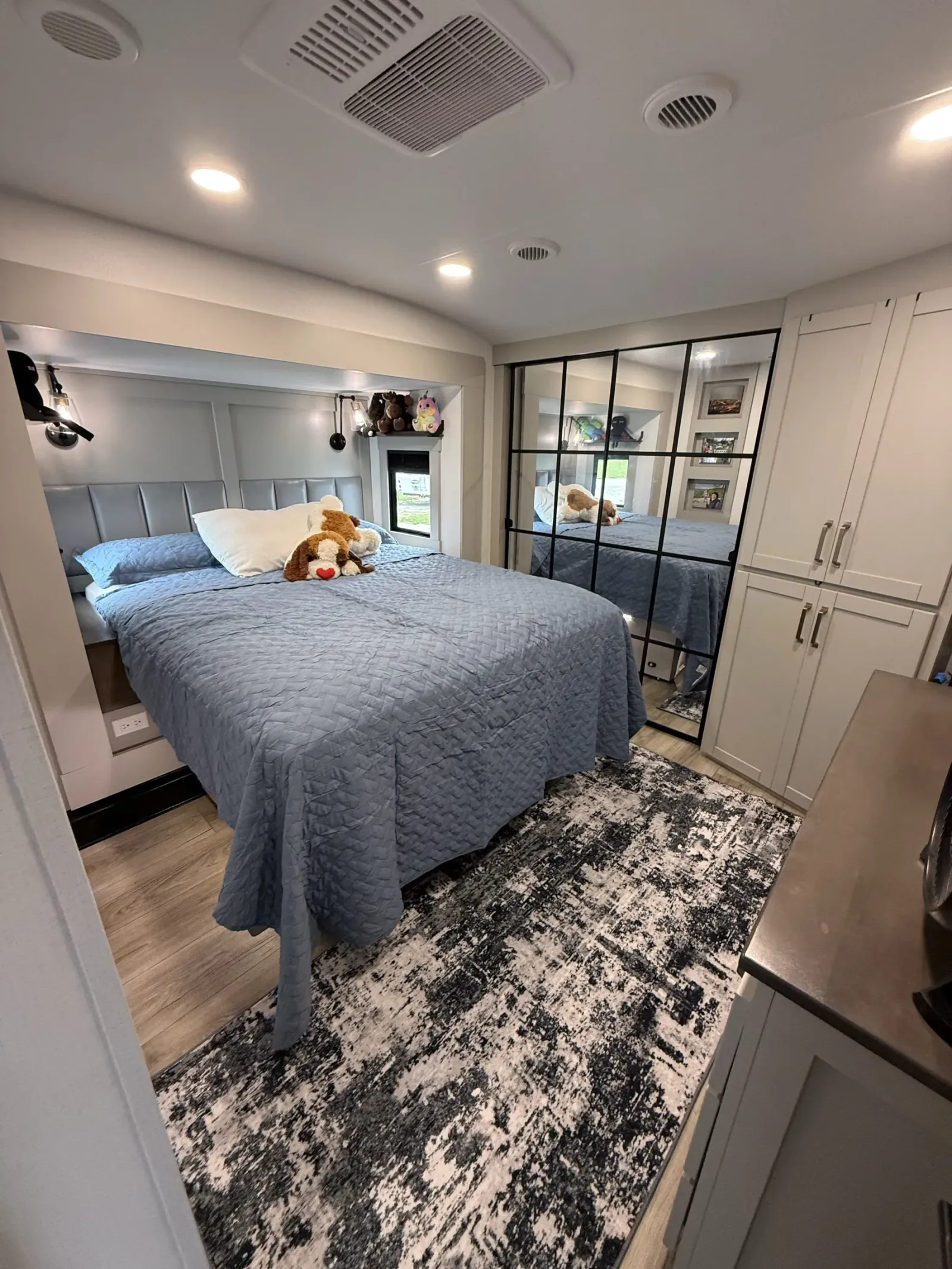 The bedroom of our Brinkley Model Z 3515, with the bed, a patterned rug and a glass-paneled closet door