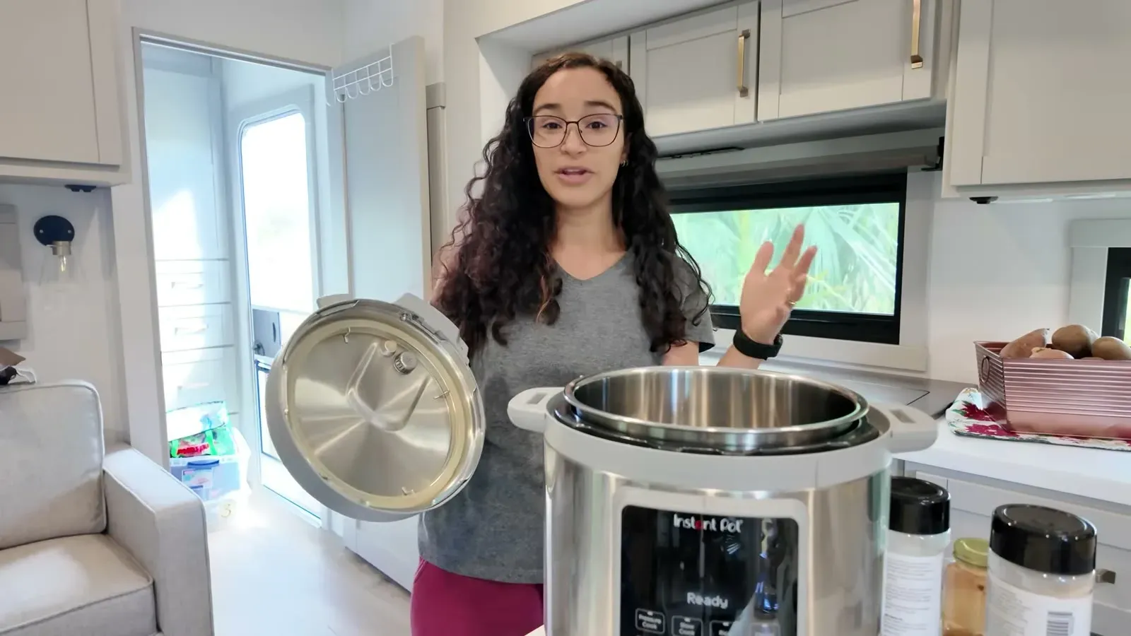 Fabiola lifting the Instant Pot lid at the kitchen island for the first proper meal of the boondocking challenge.