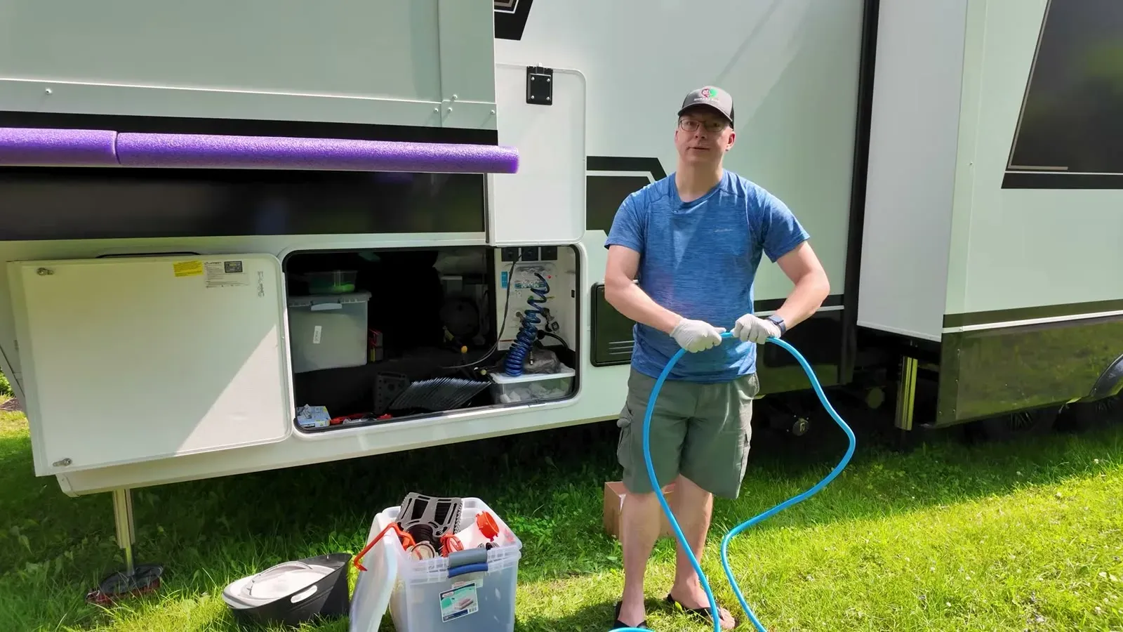 Nathan pulls the sewer hose that came with the rig's starter kit out of the storage bay.