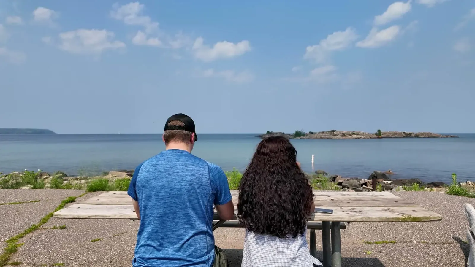The two of us at a picnic table eating pasties with Lake Superior stretched out in front of us.