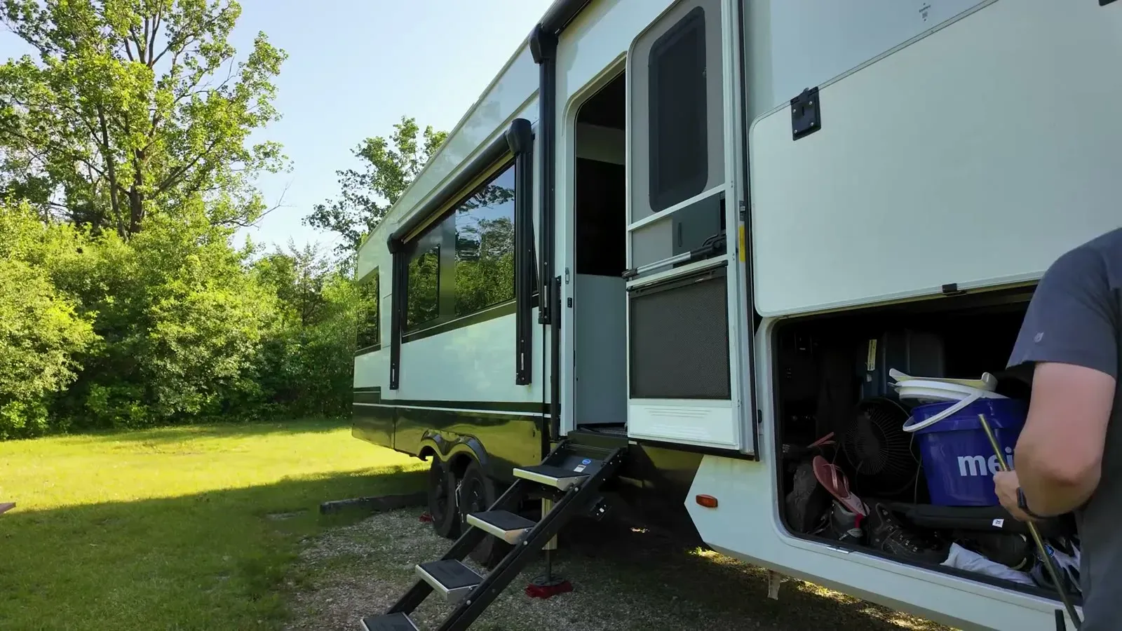 Steps down and the storage bay open as we unpack the fifth wheel into our shady, grassy site for the week.