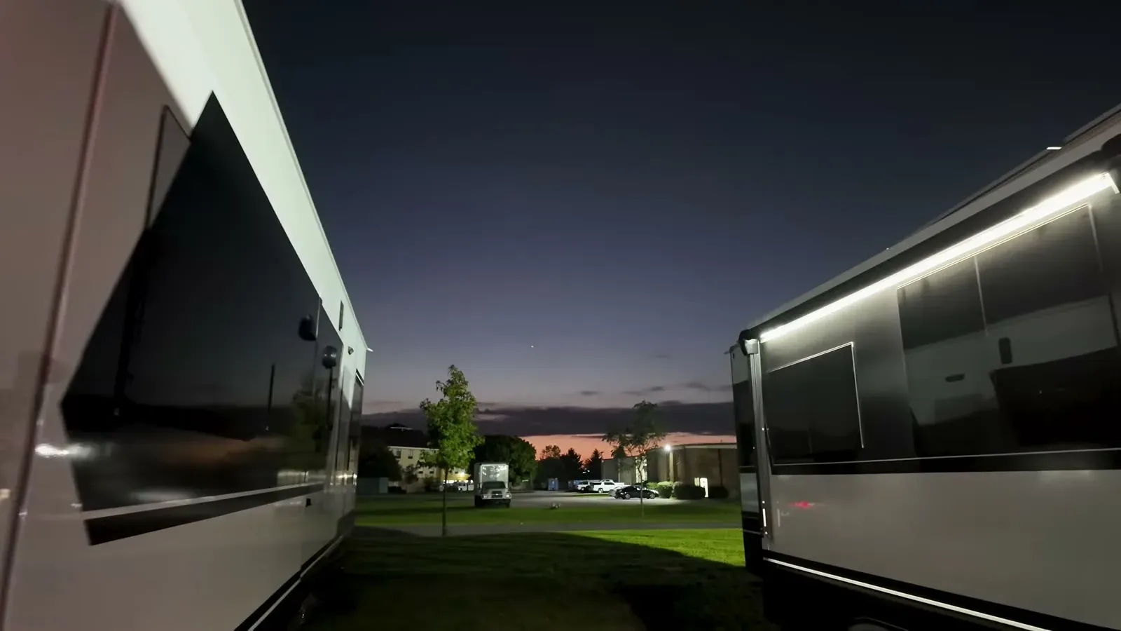 Sunrise breaking over the Brinkley service center lot, framed between two rigs on drop-off morning.