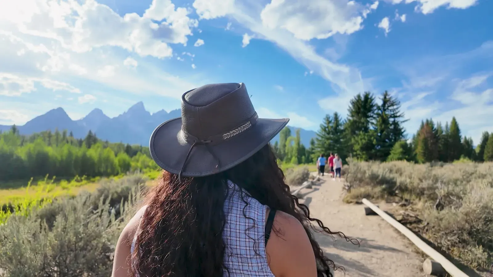 Fabiola in her new cowboy hat on the path at Schwabacher Landing, looking toward the Tetons