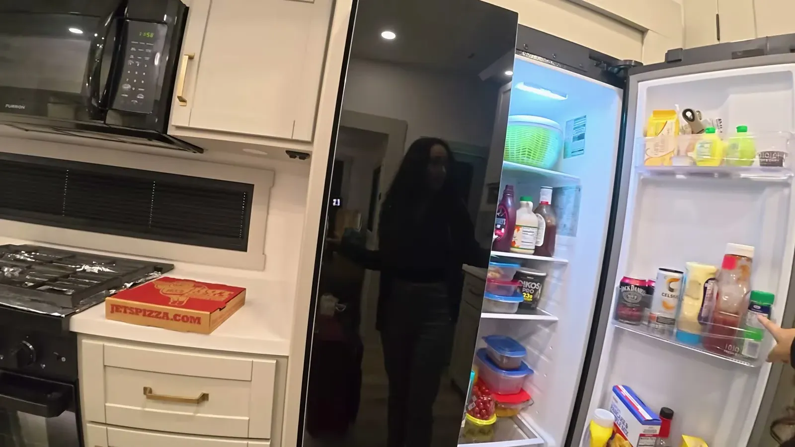 The replacement refrigerator with both doors open, already restocked with our food after the swap.