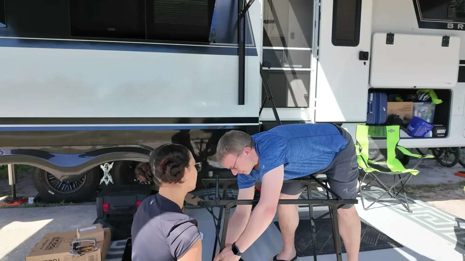 Nathan bends nearly in half to reach the new camping table, which topped out around knee height outside the fifth wheel.