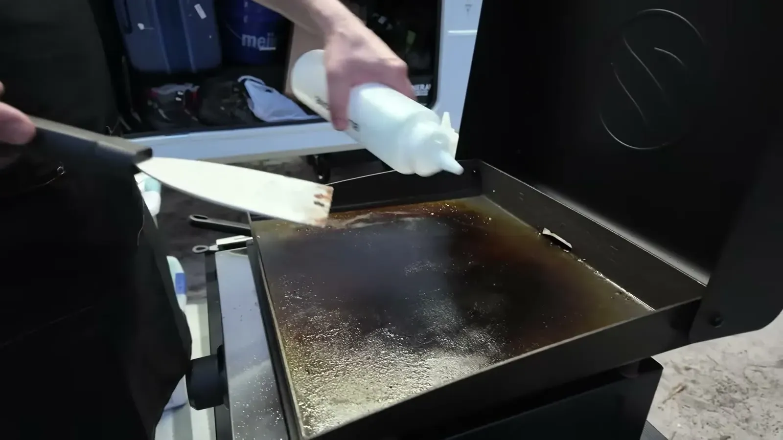 A quick squeeze of oil goes onto the freshly scraped cooktop, the last step of the two minute cleanup.