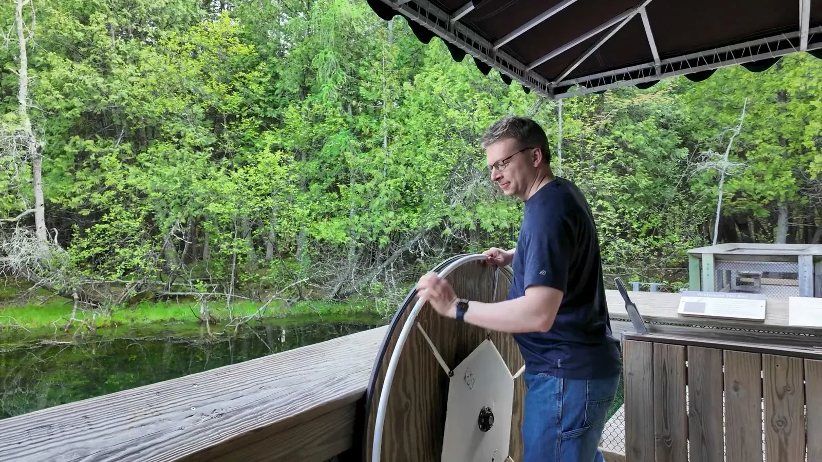 Nathan turns the big wheel that pulls the observation raft across Kitch-iti-kipi.