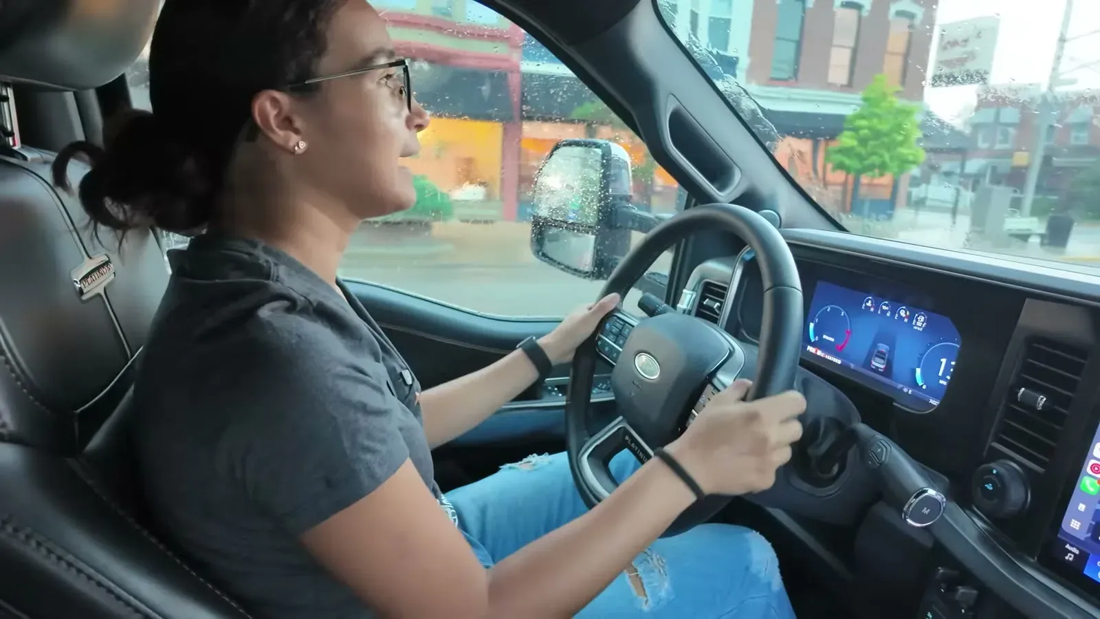 Fabiola drives through town under a darkening sky, rain spotting the glass as the tornado watch comes in.