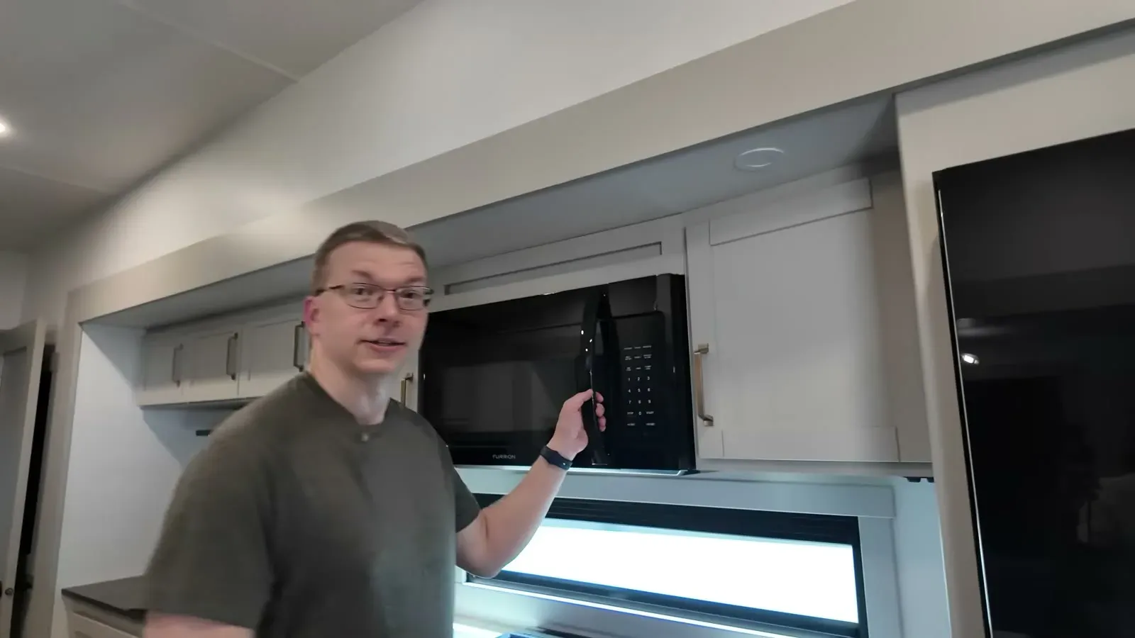 Nathan swings open the microwave door while walking through what the factory fixed on our warranty list.