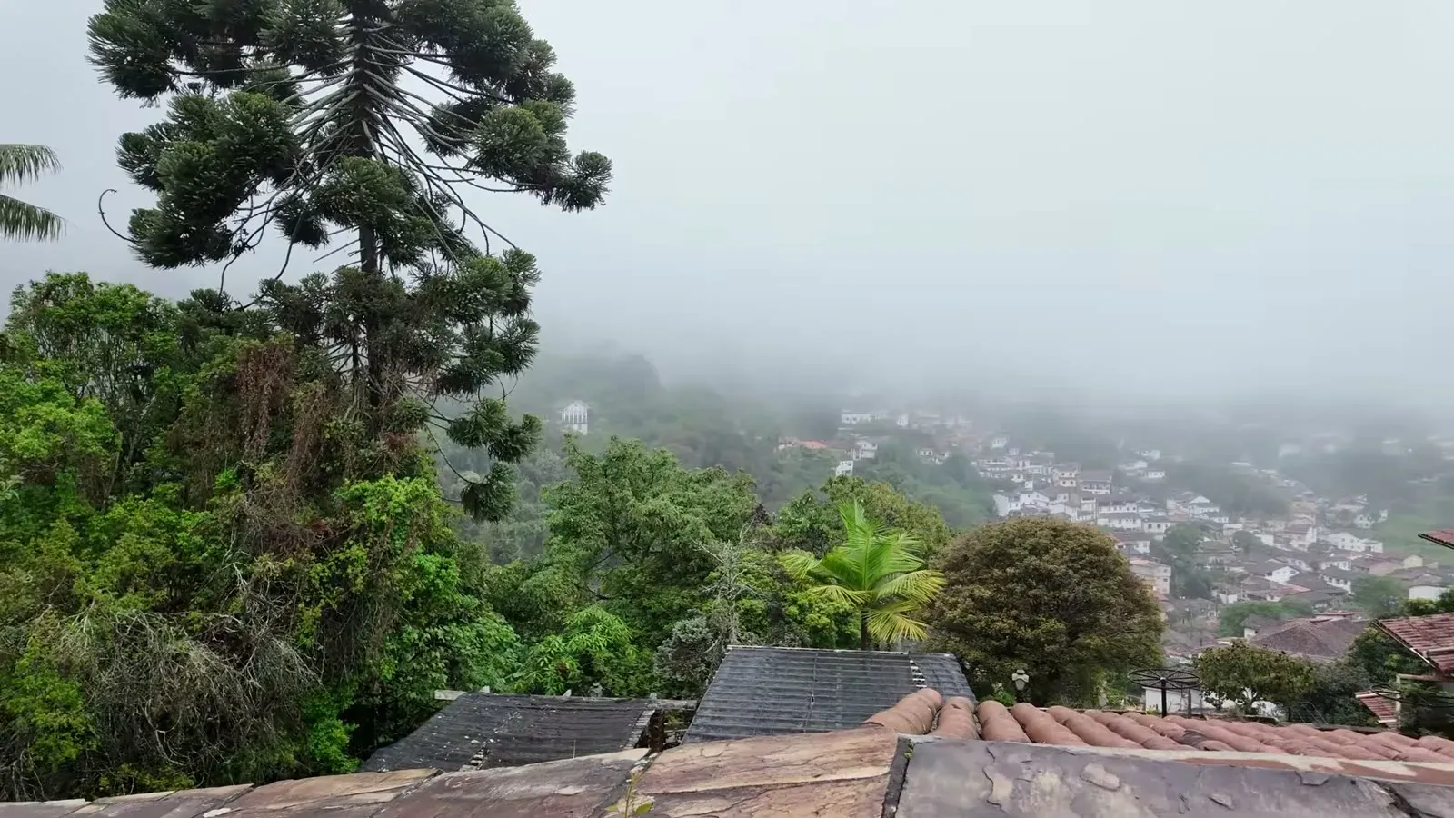 Looking out over Ouro Preto's terracotta rooftops from our room, with the hillside town fading into low clouds.