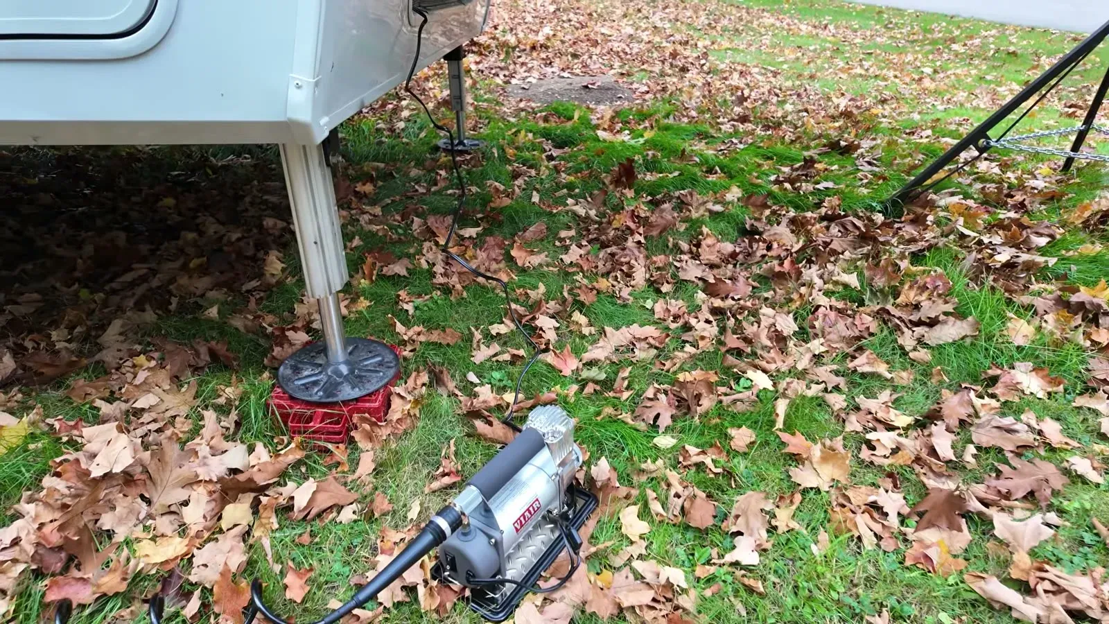 The VIAIR portable compressor set up on the ground next to the fifth wheel, hose run out and ready to air up.