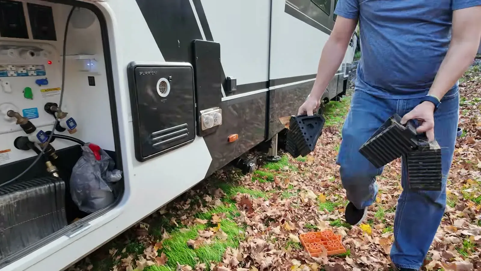 Carrying the leveling blocks and wheel chocks back to the basement bay through a season's worth of fallen leaves.