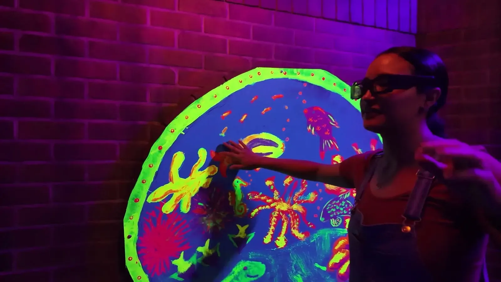 Fabiola feeling her way past a glowing blacklight mural inside Amazing Chicago's Funhouse Maze.