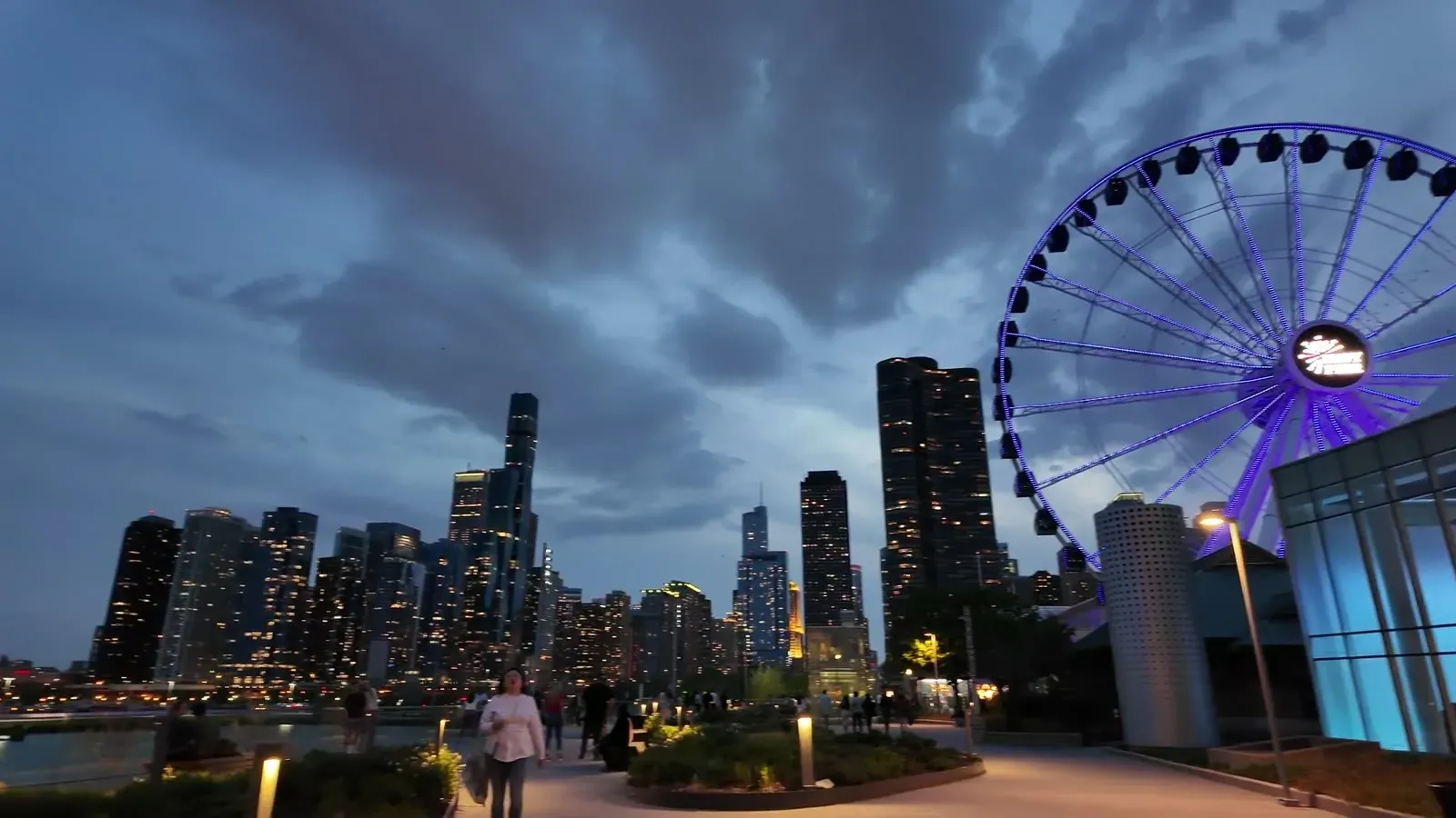 The Chicago skyline lit up at dusk from Navy Pier, with the Centennial Wheel glowing on the right.