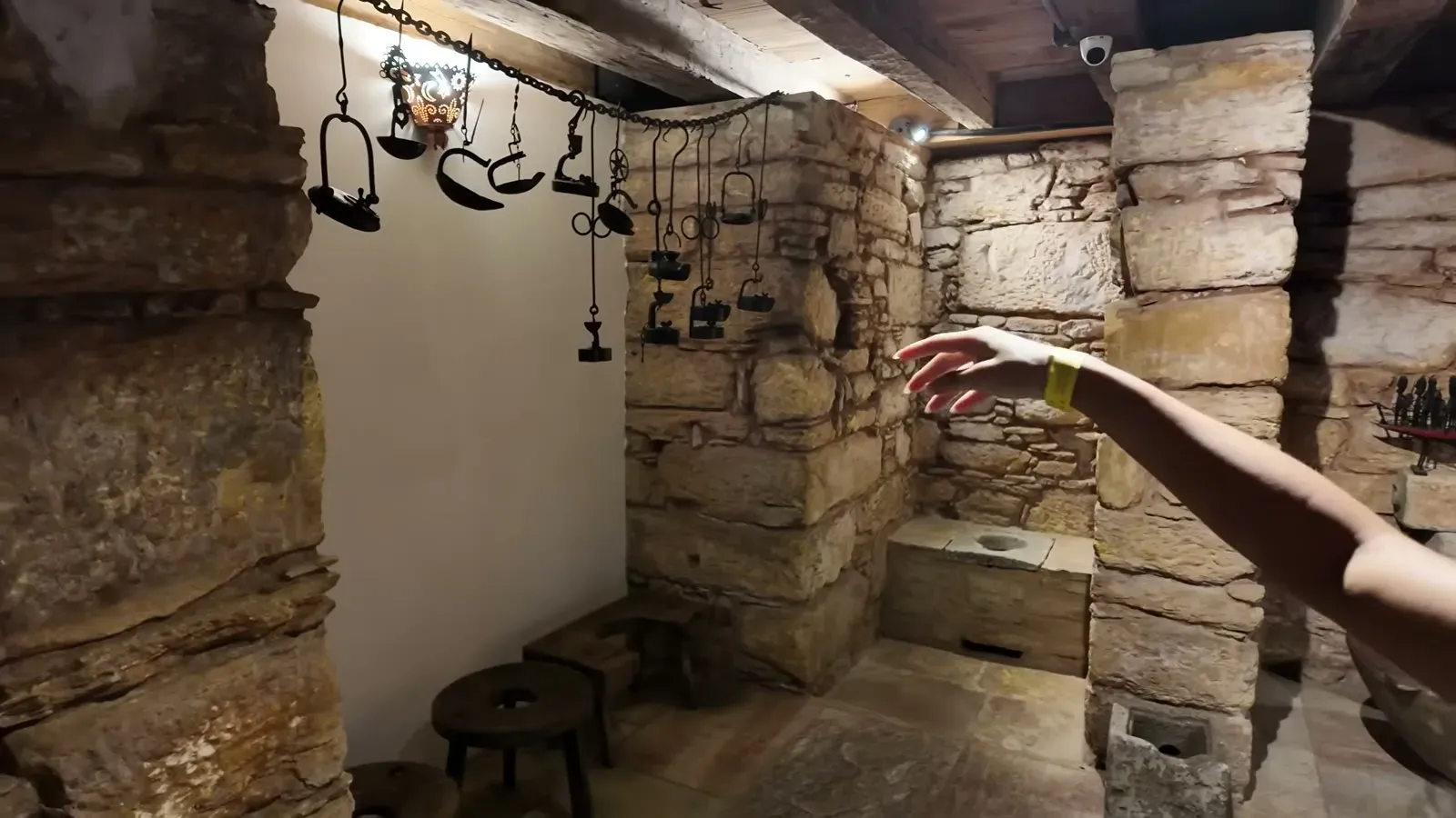 Inside the stone-walled gold mine under the palace, with old iron mining tools hanging from the beams.