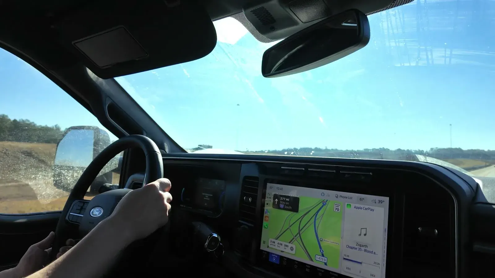 Hands on the F350's wheel with a bright sky through the windshield on the last leg toward Florida.