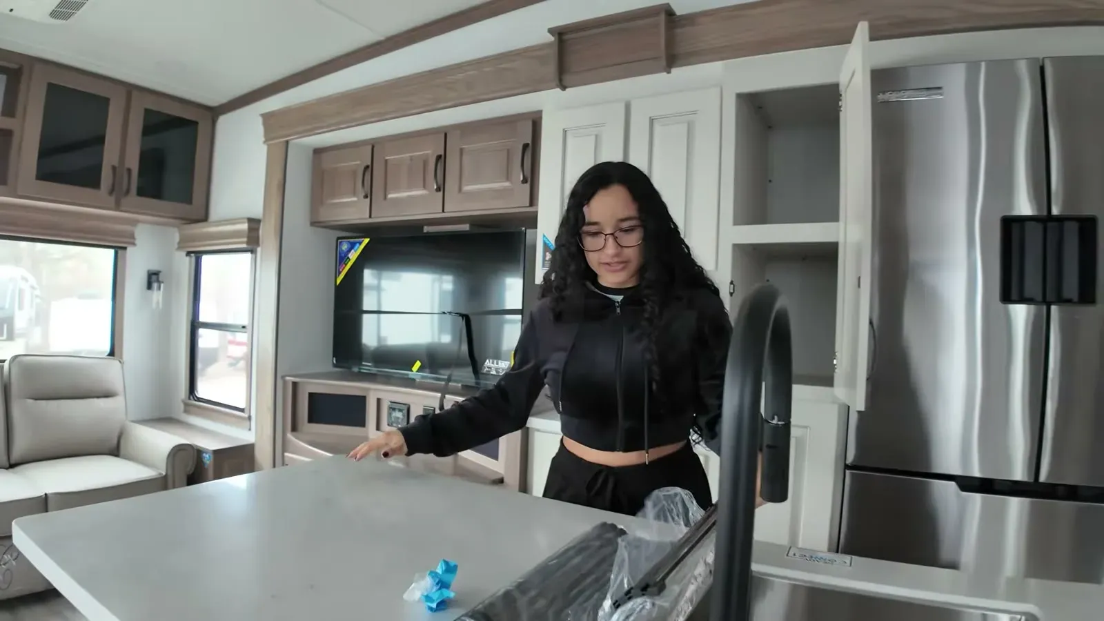 Fabiola checking out the kitchen island and residential fridge inside the Alliance Paradigm 295MK.