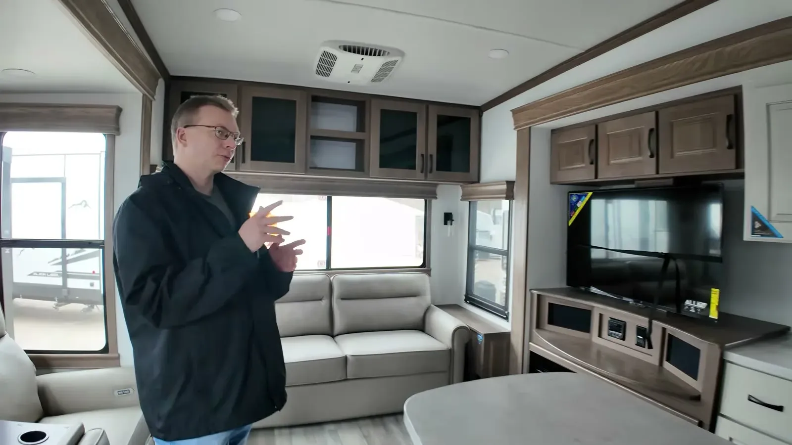 Nathan talking through the rear living area of the Alliance Paradigm 340RL, with the couch and TV wall behind him.