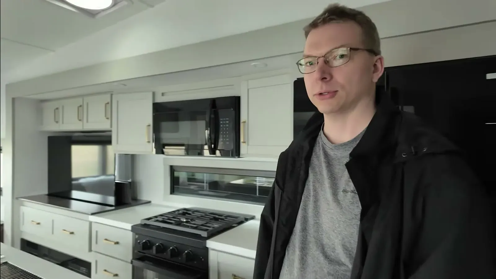 Nathan in the Brinkley Model Z 2900 kitchen, with its dark countertops, gas cooktop, and built-in microwave.