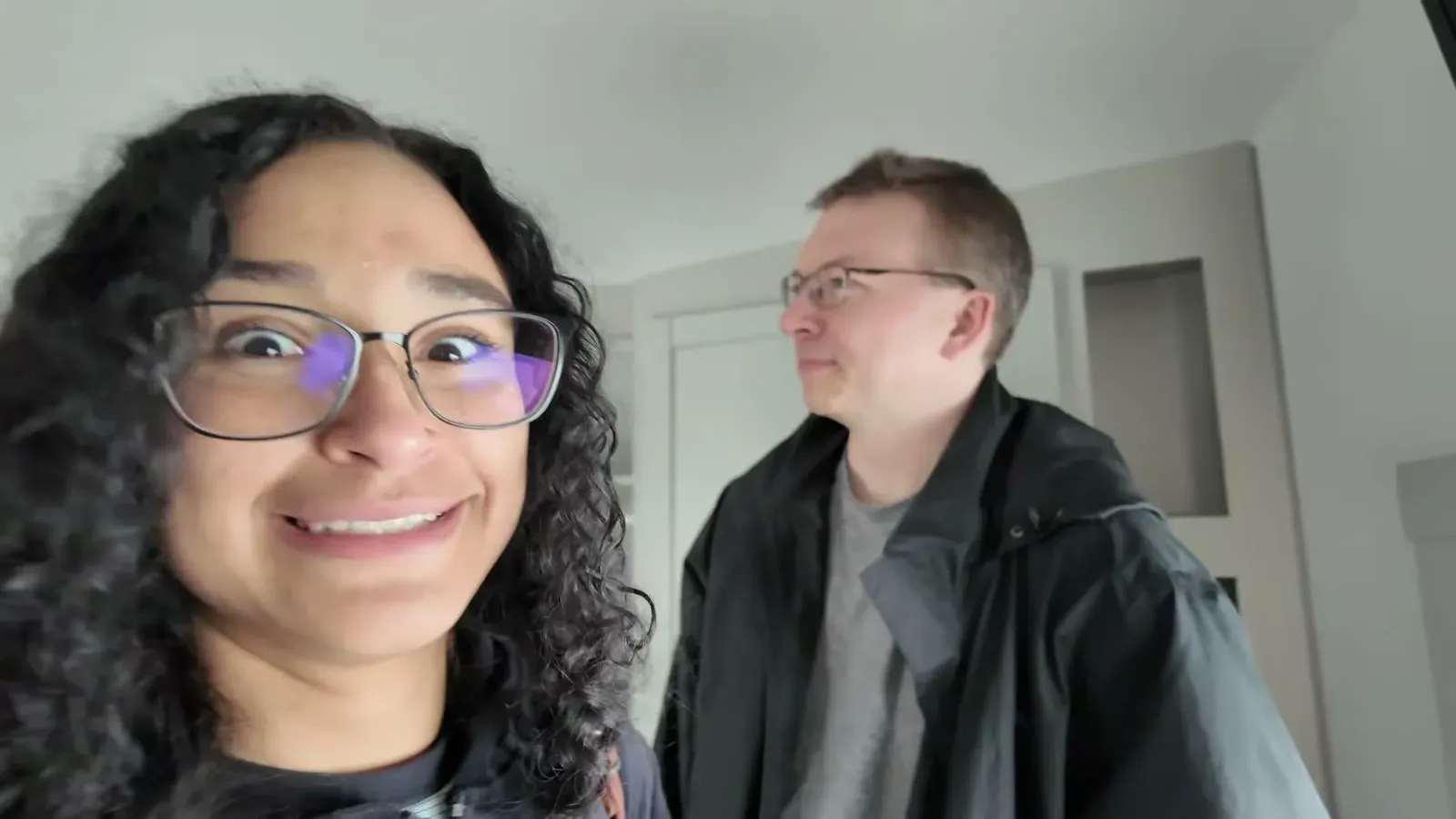 Fabiola and Nathan grinning at the camera while comparing notes after touring all four fifth wheels.