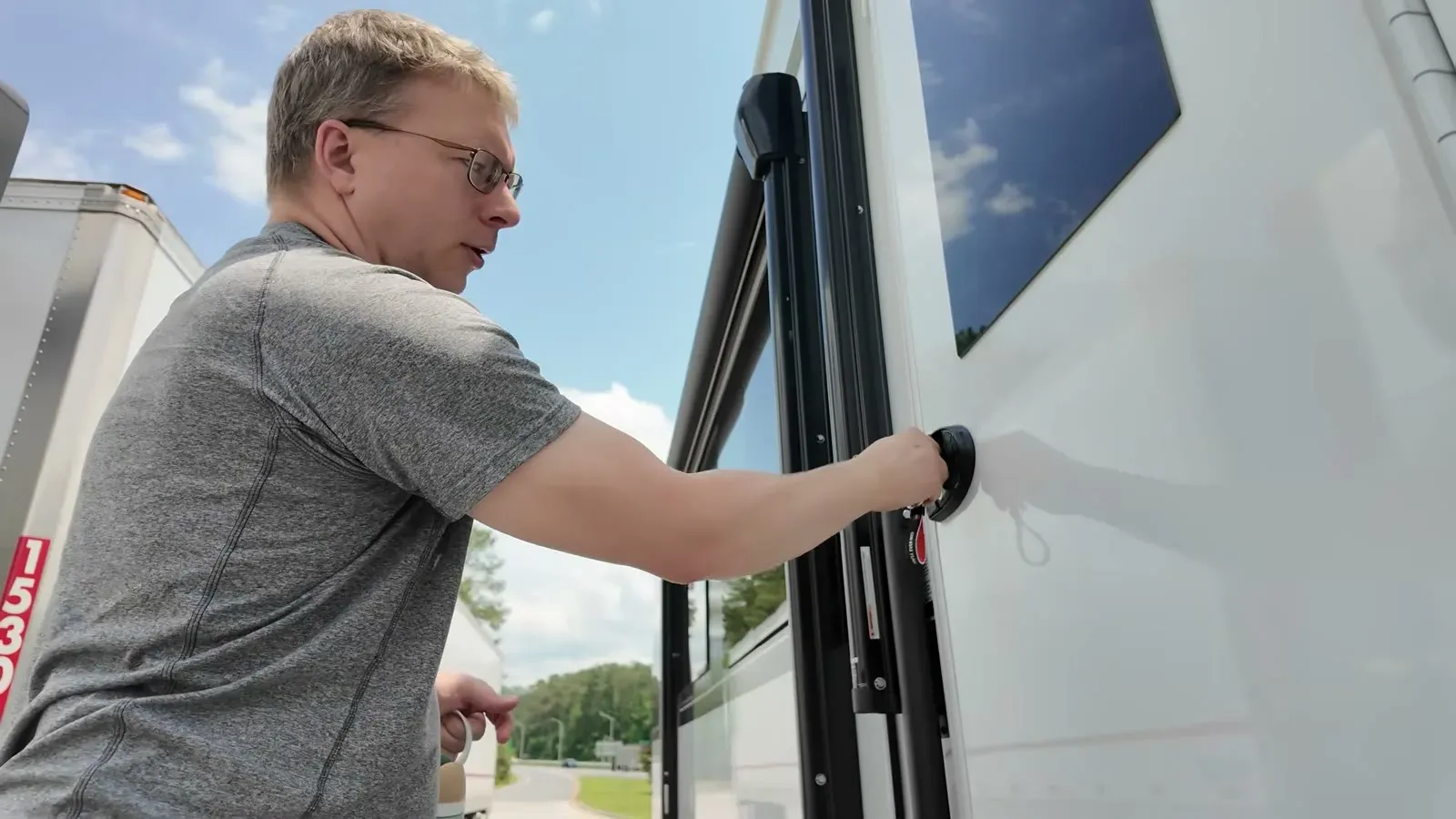 Nathan grips the RV entry door handle to test the latch that rode the whole drive unlocked.