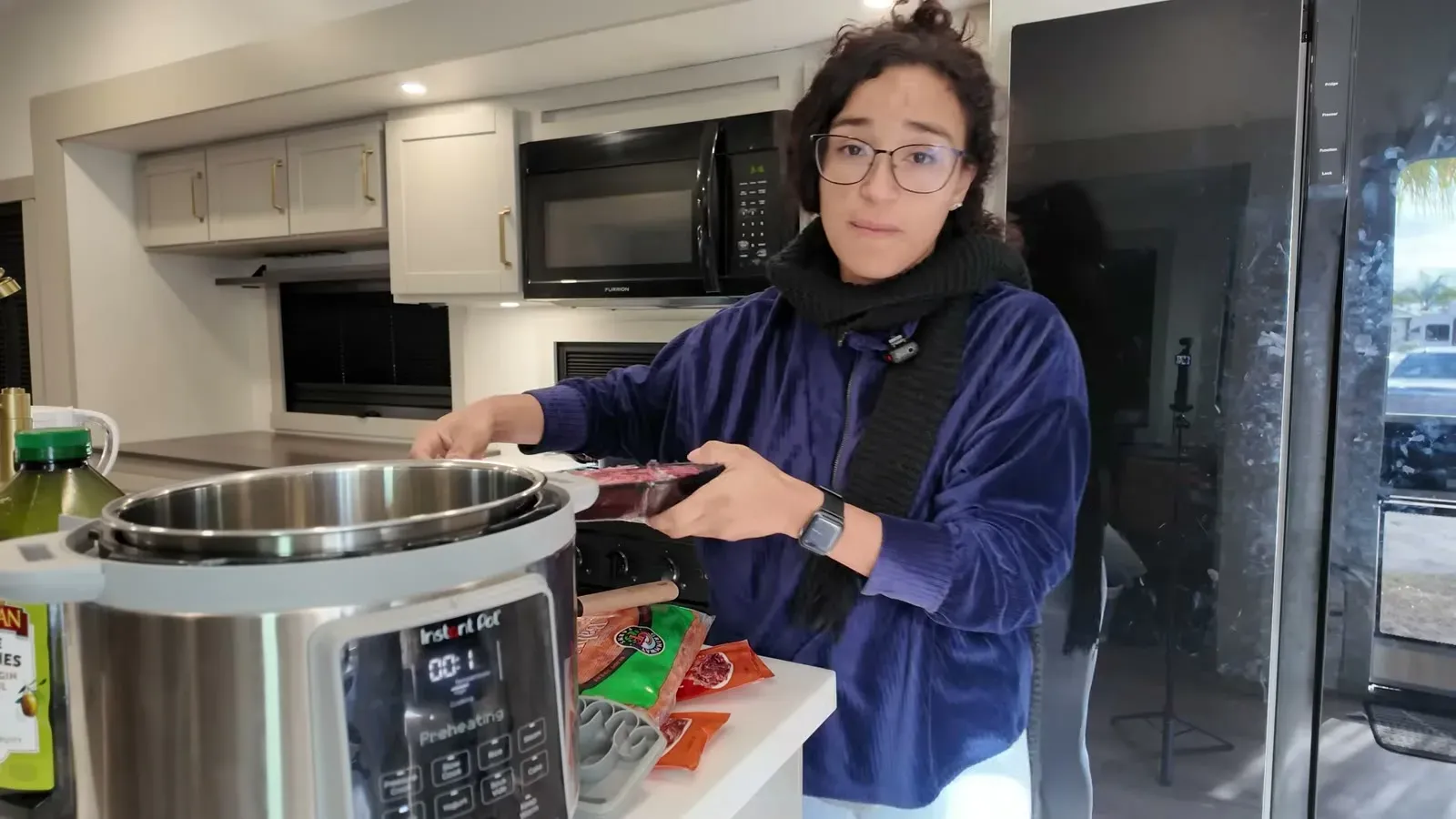 Fabiola holds a package of stew meat next to the Instant Pot in the RV kitchen, ready to start the beef stew.