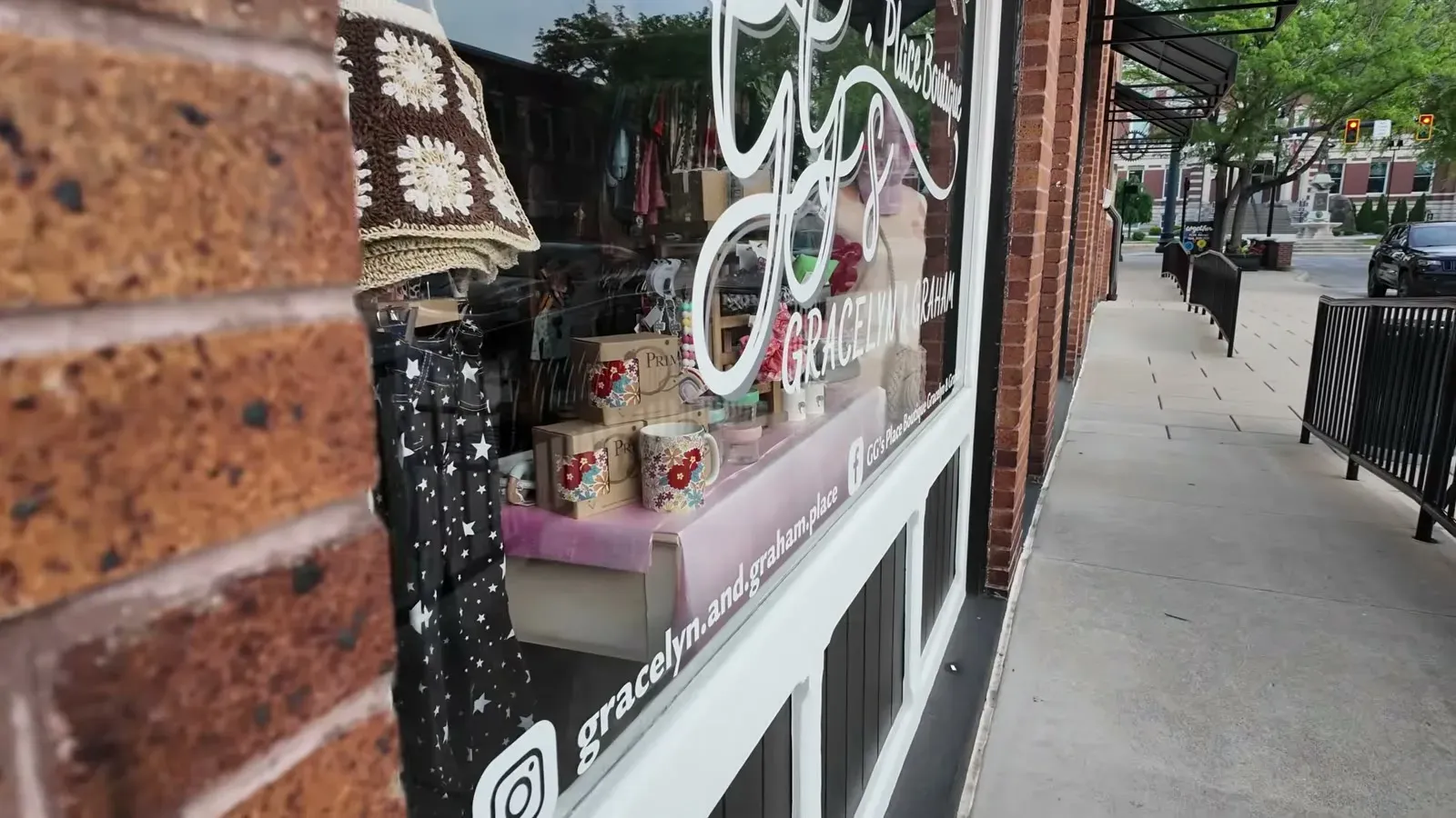 A brick storefront and boutique window along the sidewalk in downtown Franklin, Indiana.