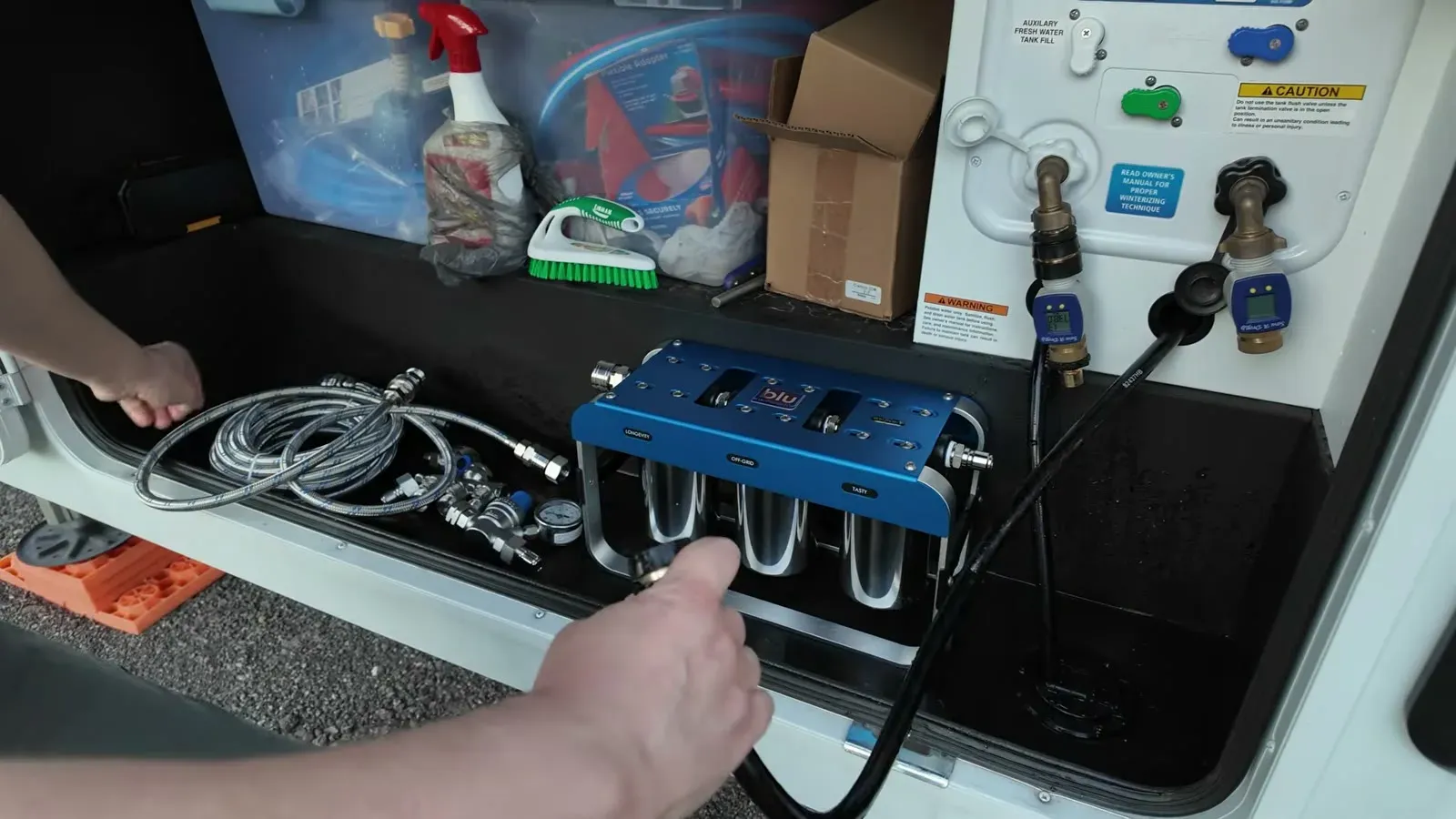 Hooking the blue AR3 three-stage filter up to the quick connects inside the Brinkley's water bay.