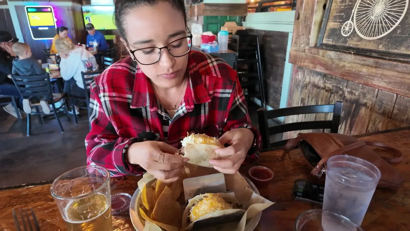 Fabiola digging into dinner at a wooden table inside Rusted Spoke Brewing Co in Mackinaw City.