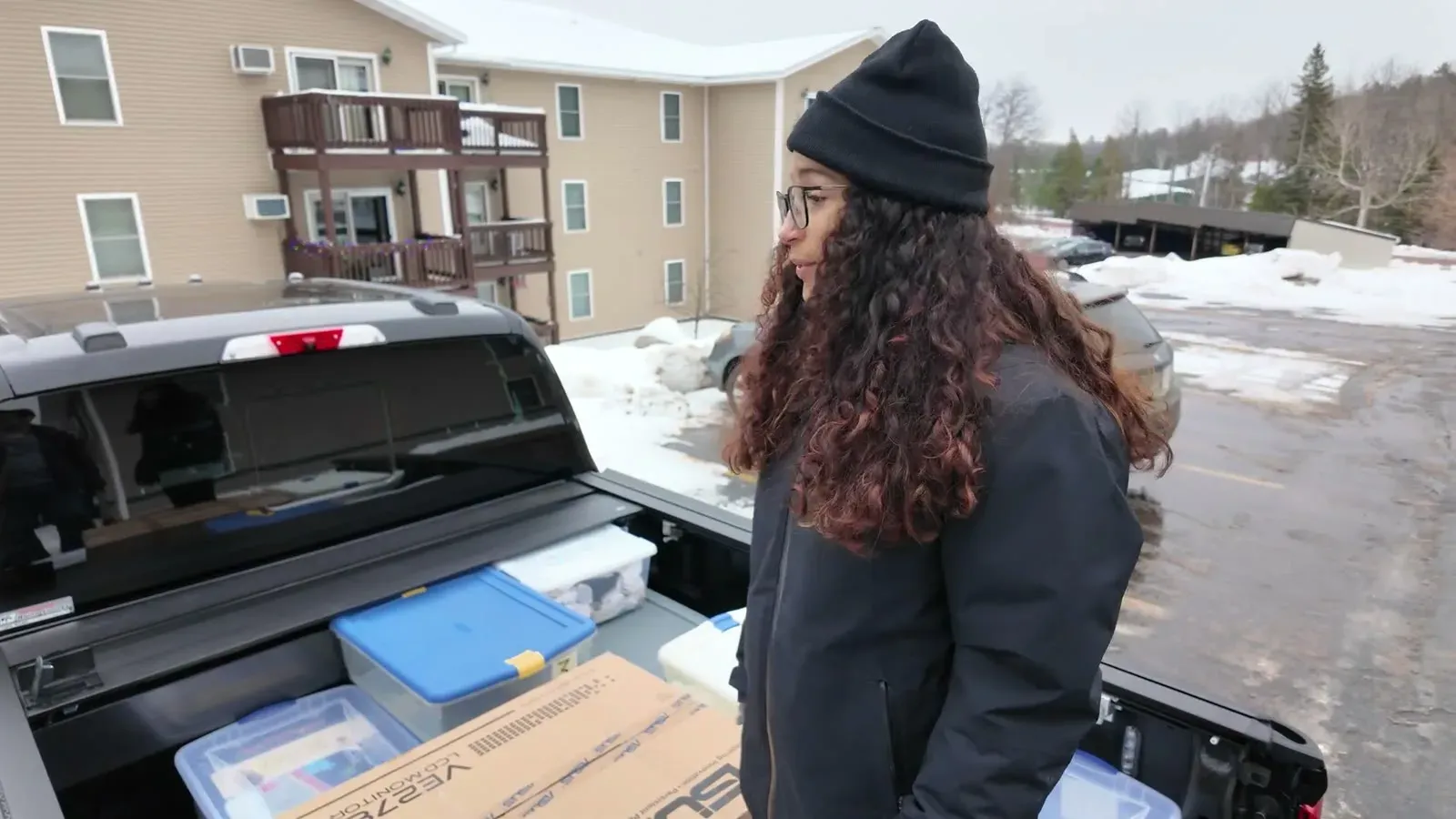Fabiola at the open tailgate with the bed half full of totes and boxes during our test pack.