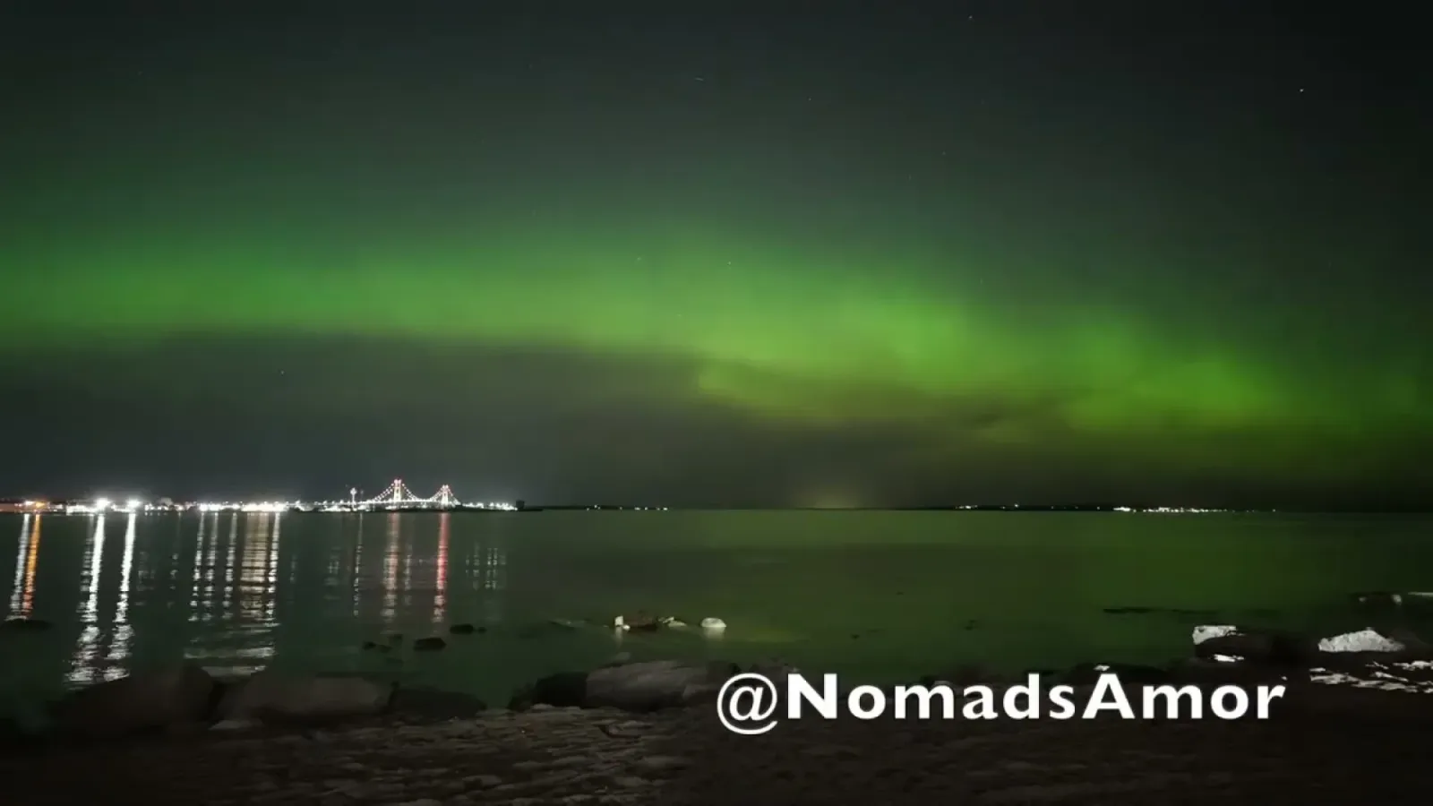 Pink and green aurora borealis filling the night sky over the Mackinac Bridge in Mackinaw City, Michigan