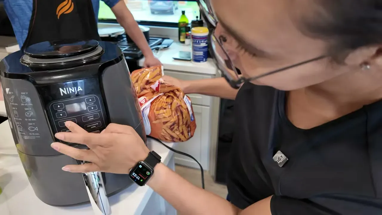 Pouring fries into our Ninja air fryer, powered by our solar and battery system