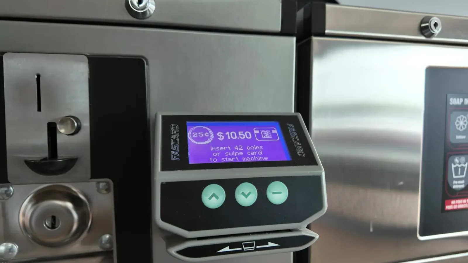 A laundromat washing machine display reading $10.50, insert 42 coins or swipe card to start machine
