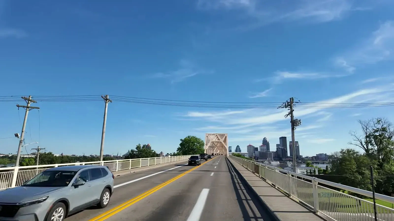 Crossing the Ohio River on the highway bridge with the Louisville skyline coming into view ahead.