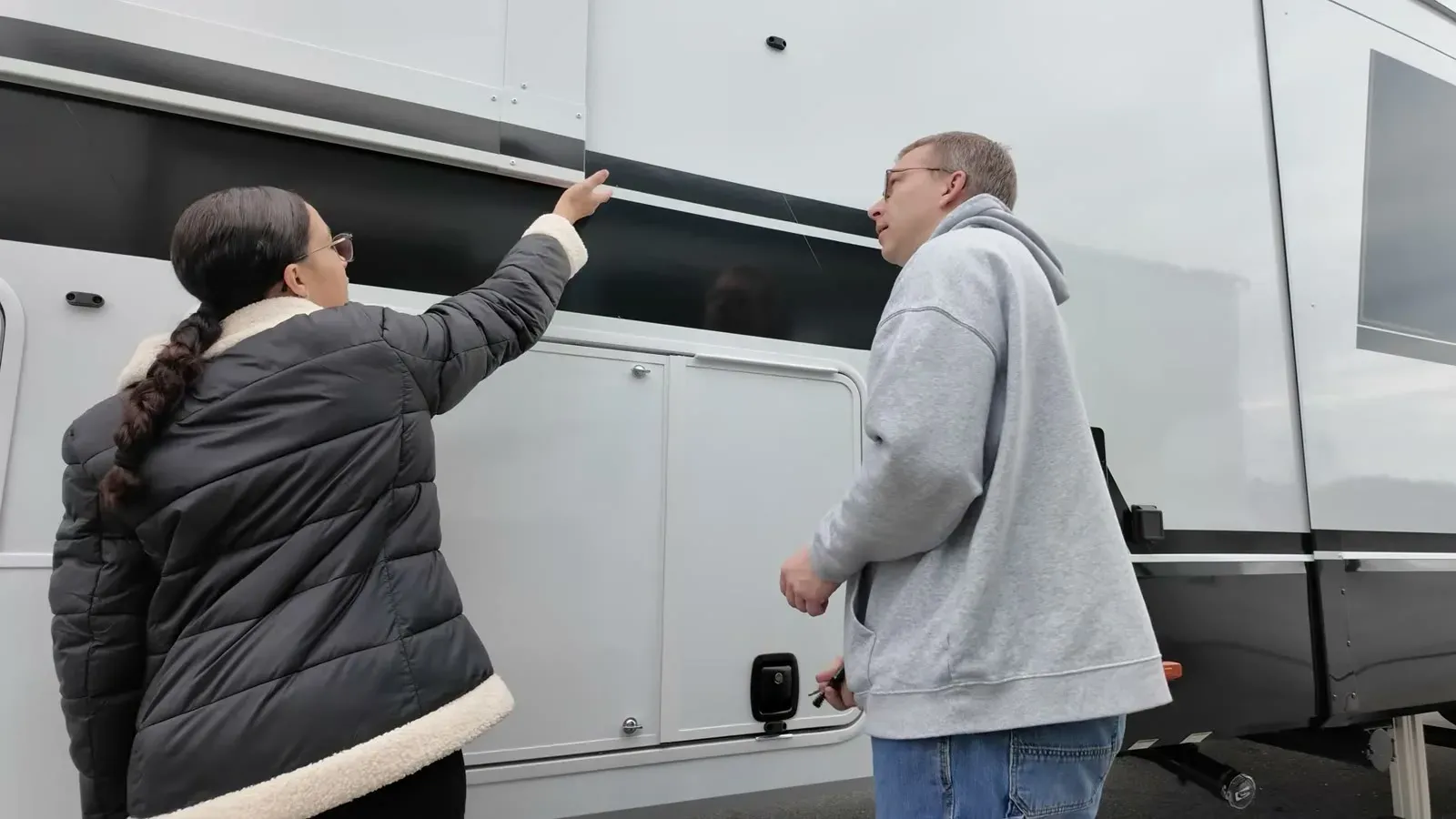 Fabiola and Nathan close up an exterior compartment on the fifth wheel while getting it road ready.
