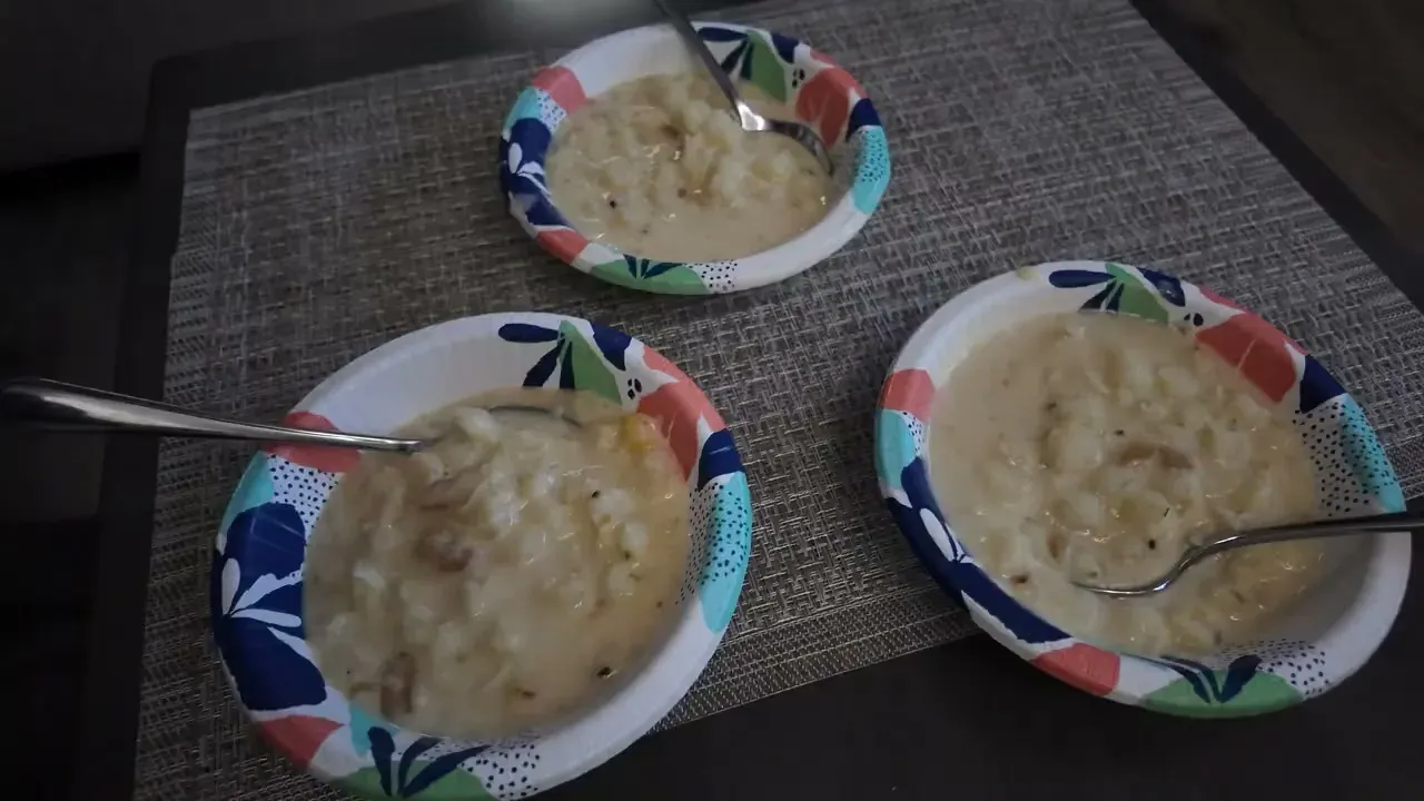 Three bowls of finished canjica with spoons on a placemat on the RV table