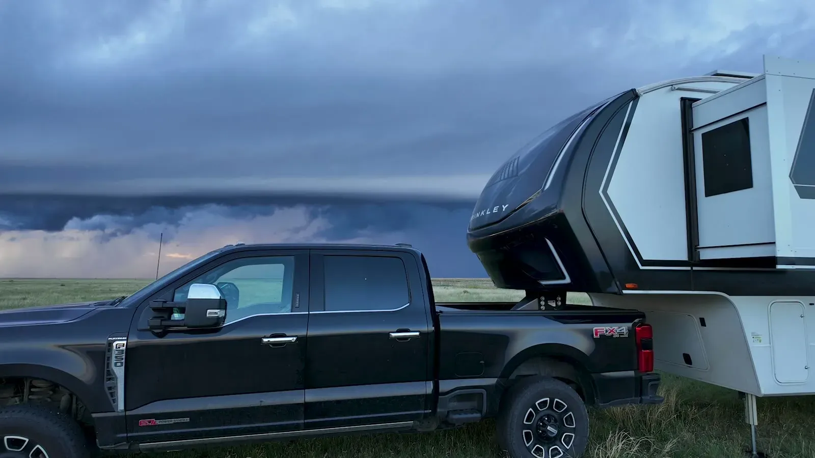 Dark storm clouds over our truck and fifth wheel on the grassland