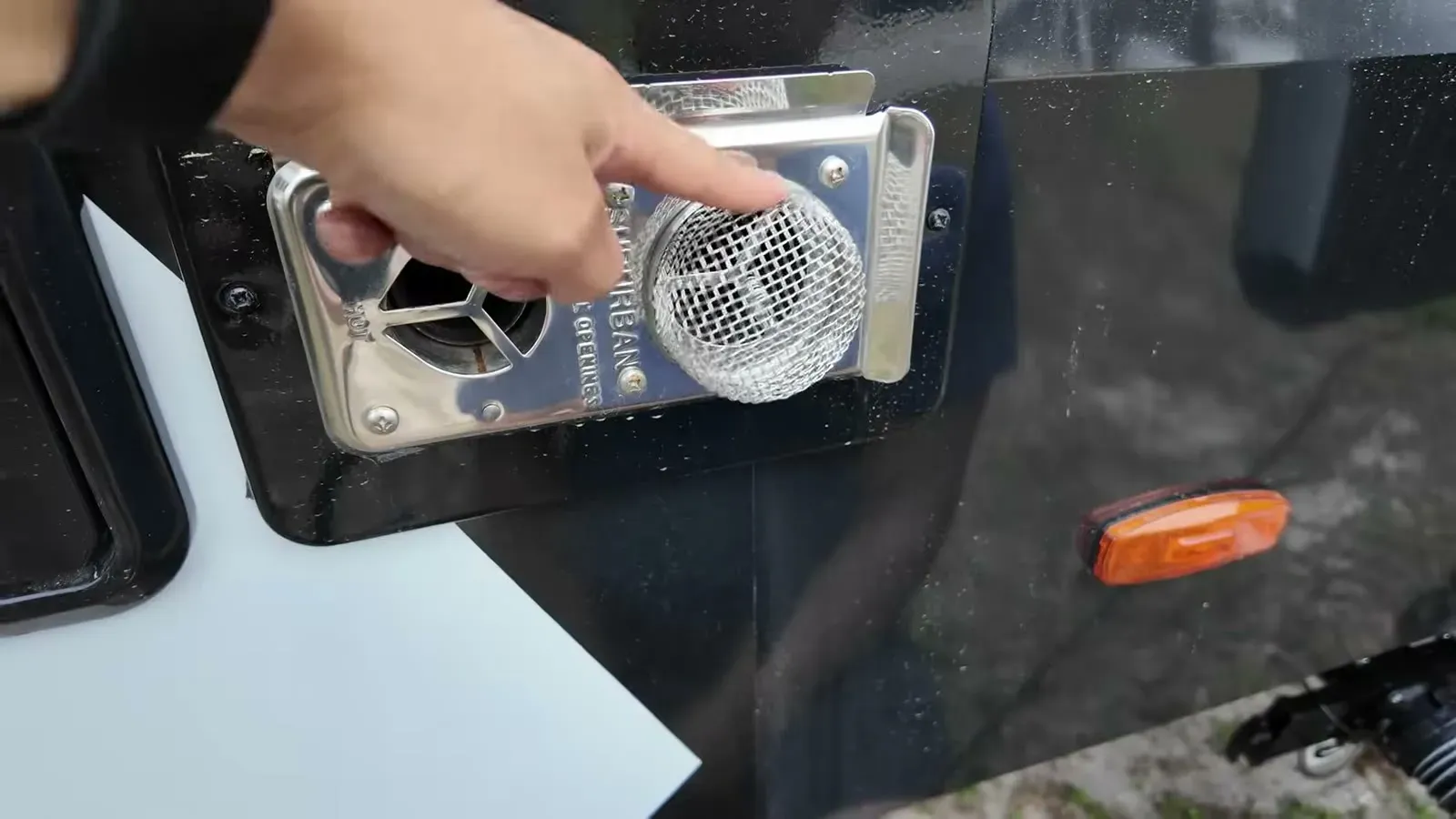 A stainless mesh bug screen going over the furnace vent on the Brinkley's black lower panel.